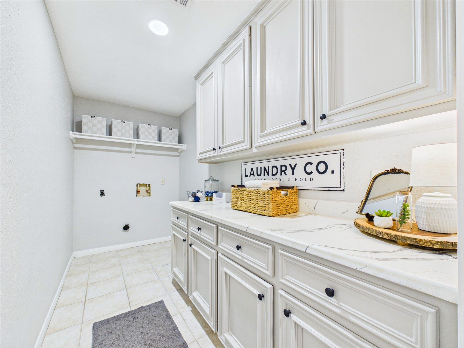 6209 Brookdale Drive, League City, TX 77573 Bright and spacious laundry room featuring ample cabinetry, sleek countertops, and organized shelving for a functional and stylish workspace.