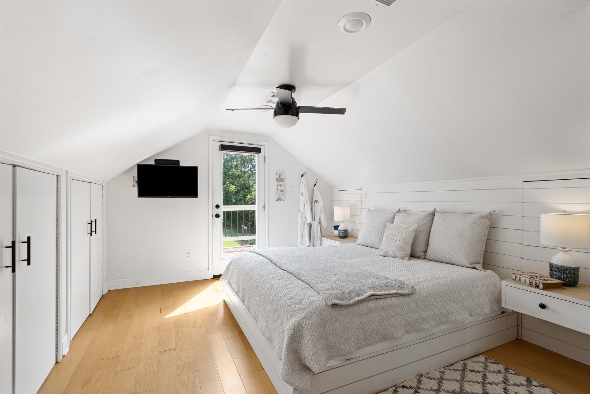 34310 High Point Drive, Magnolia, TX 77355 This cozy bedroom features a sloped ceiling, beautiful floors and accent wall. It has built-in storage, and a glass door leading to an outdoor balcony, creating a bright and inviting space.