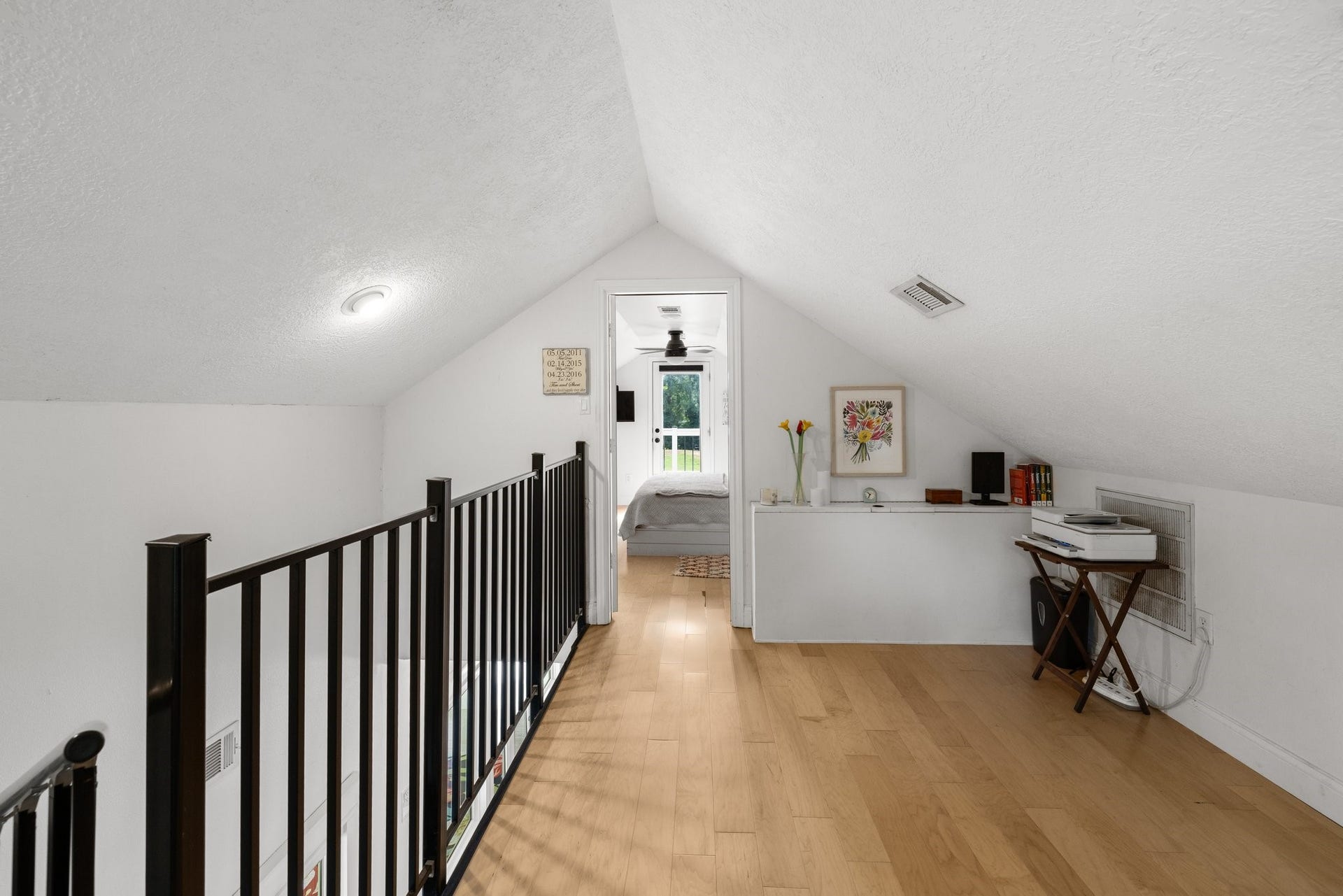 34310 High Point Drive, Magnolia, TX 77355 This photo showcases a loft with a sloped ceiling and wonterful flooring. It features a small railing, built-in shelf space, and leads to a cozy bedroom, creating a charming and functional upper-level space.