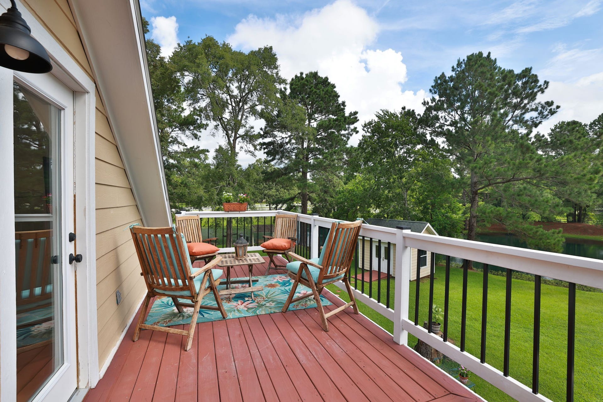 34310 High Point Drive, Magnolia, TX 77355 This inviting balcony features a cozy seating area and the most stunning views of the property. So serene and perfect for relaxing outdoors.