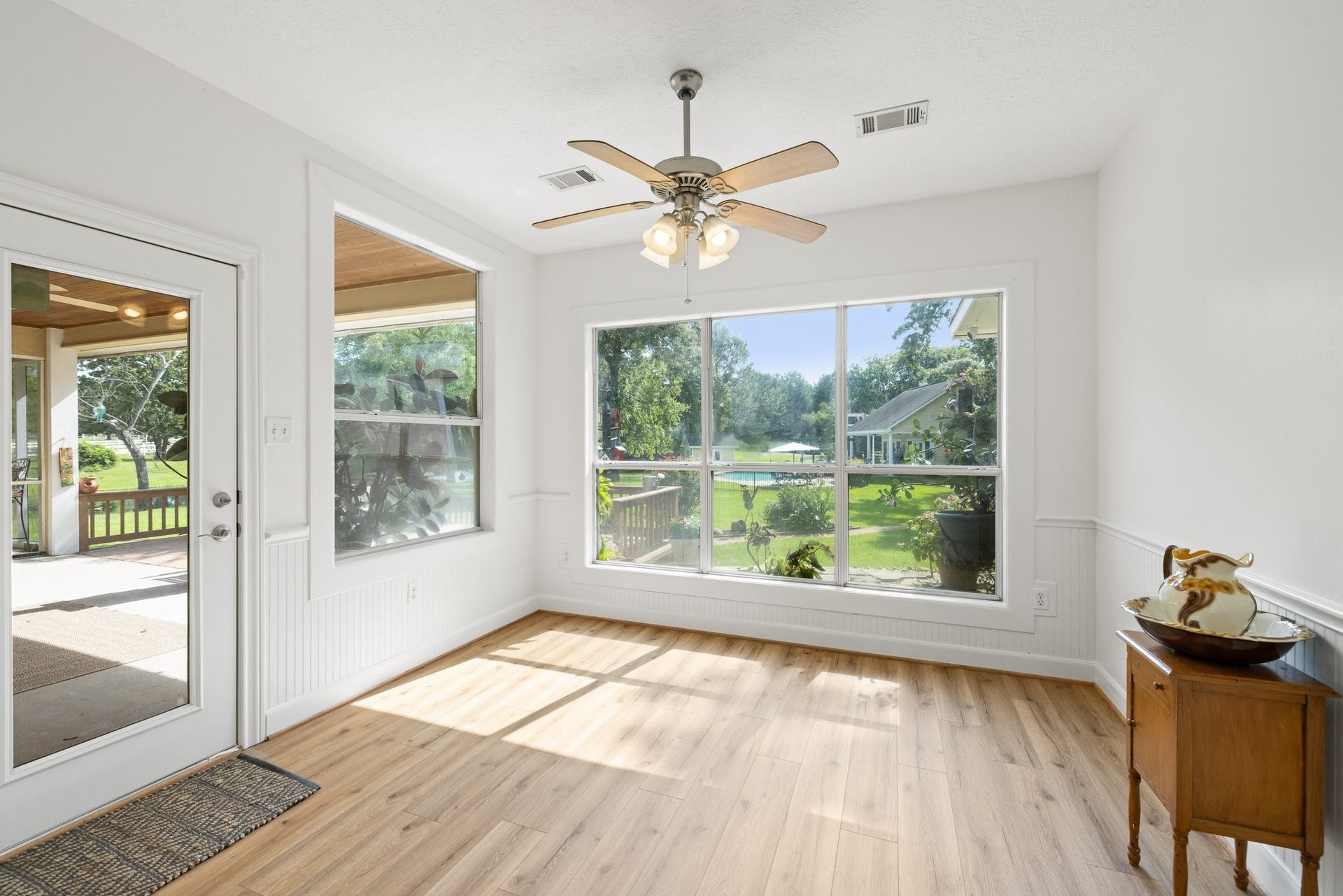 34310 High Point Drive, Magnolia, TX 77355 Bright and airy breakfast area with large windows, offering beautiful views of the backyard. Features beautiful vinyl plank flooring, a ceiling fan, and access to a covered patio. Perfect for relaxing or entertaining.