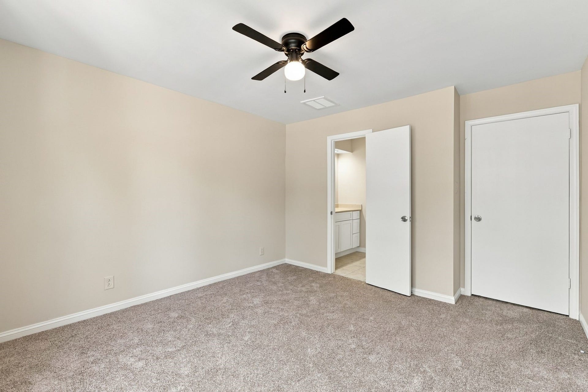 Upstairs secondary bedroom featuring neutral finishes, ceiling fan, and direct access to the secondary bathroom.