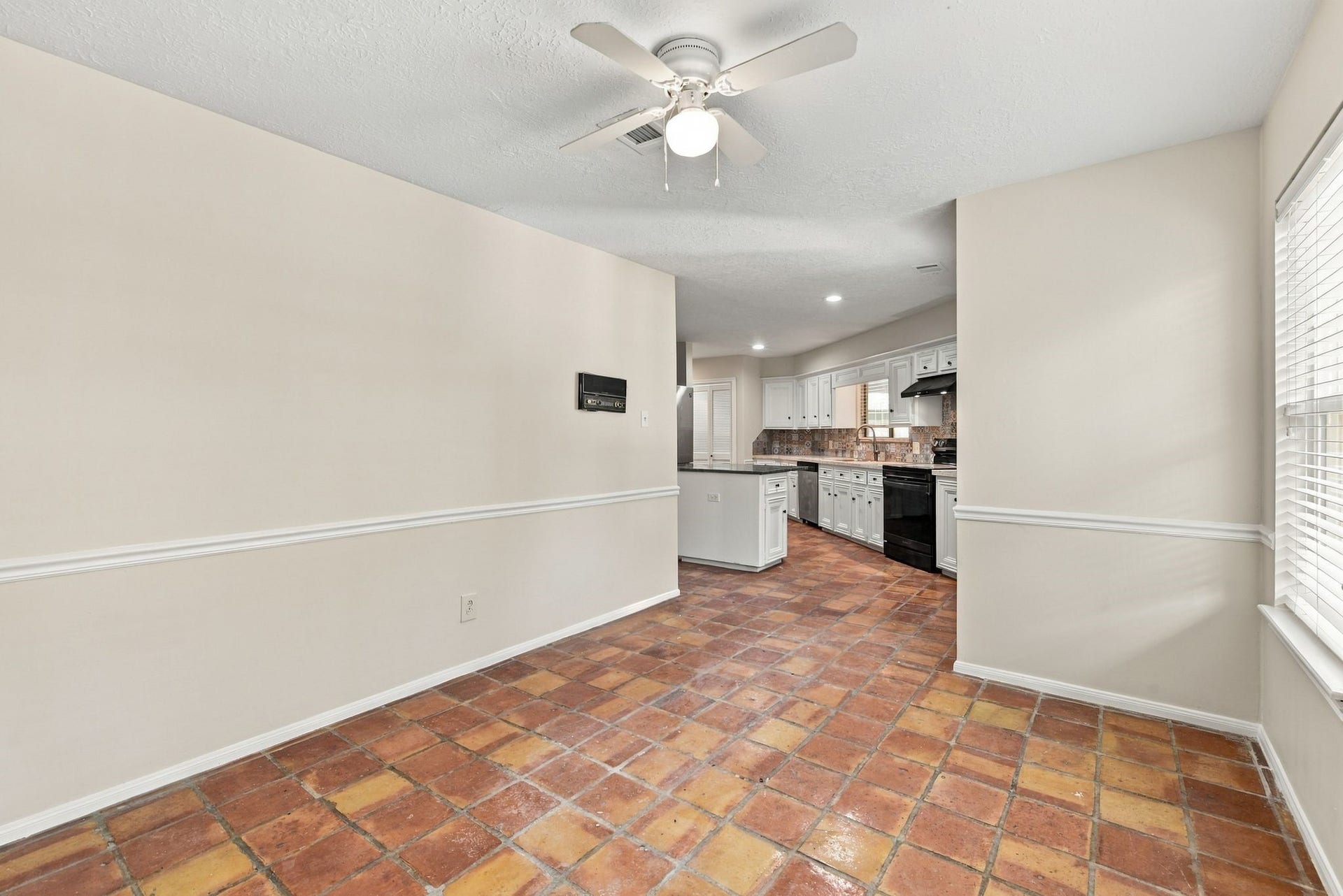 Additional view of the spacious breakfast nook featuring Saltillo tile flooring and convenient access to the kitchen.