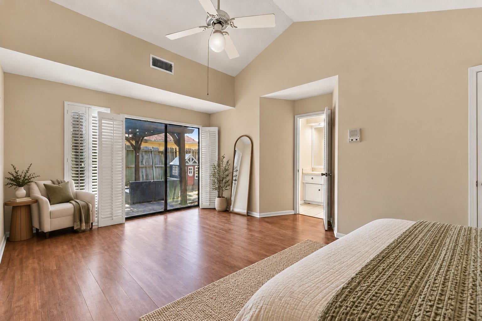 Additional virtually staged primary bedroom view featuring a cozy sitting area and sliding glass doors overlooking the outdoor space.