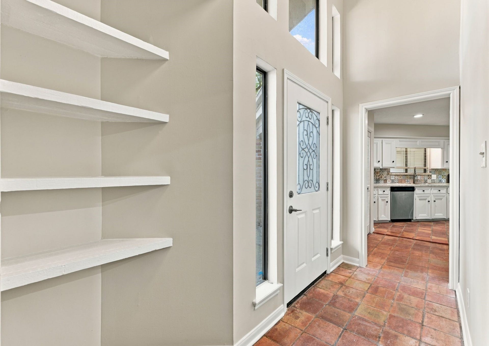 Welcoming entryway with built-in shelving and a view into the home's spacious living areas.