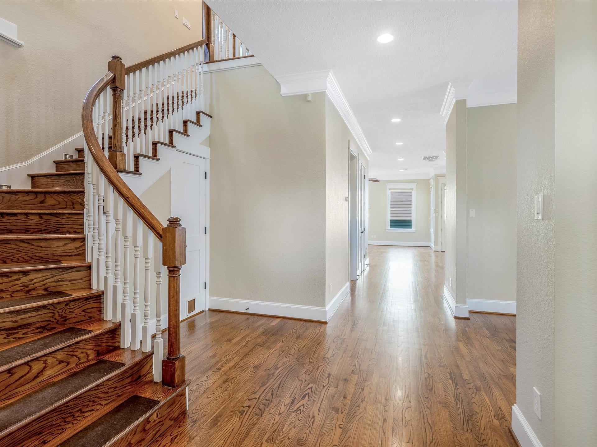 837 E 27th Street, Houston, TX 77009 Elegant entryway featuring a beautifully crafted wooden staircase and gleaming solid oak wood floors leading to a bright, spacious living area.