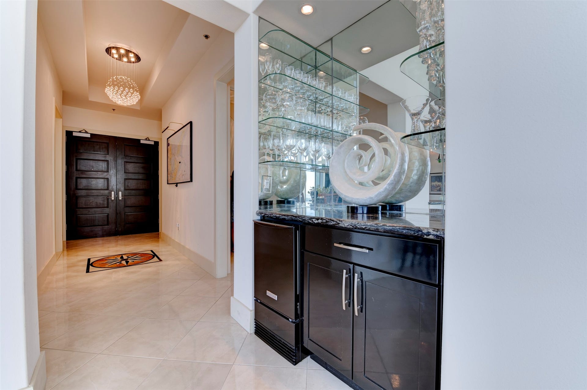 801 E Beach Drive, #BC2808, Galveston, TX 77550 Mirrored built-in bar with extensive glassware storage and a dedicated ice maker is positioned near the entry and main entertaining areas.