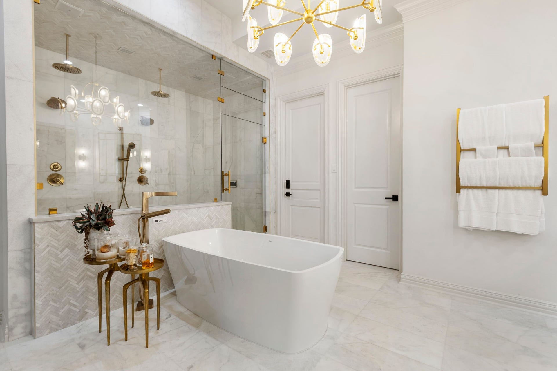 Spa-inspired - the bath also features an oversized walk-in showers and freestanding soaking tub, beneath an elegant statement chandelier.