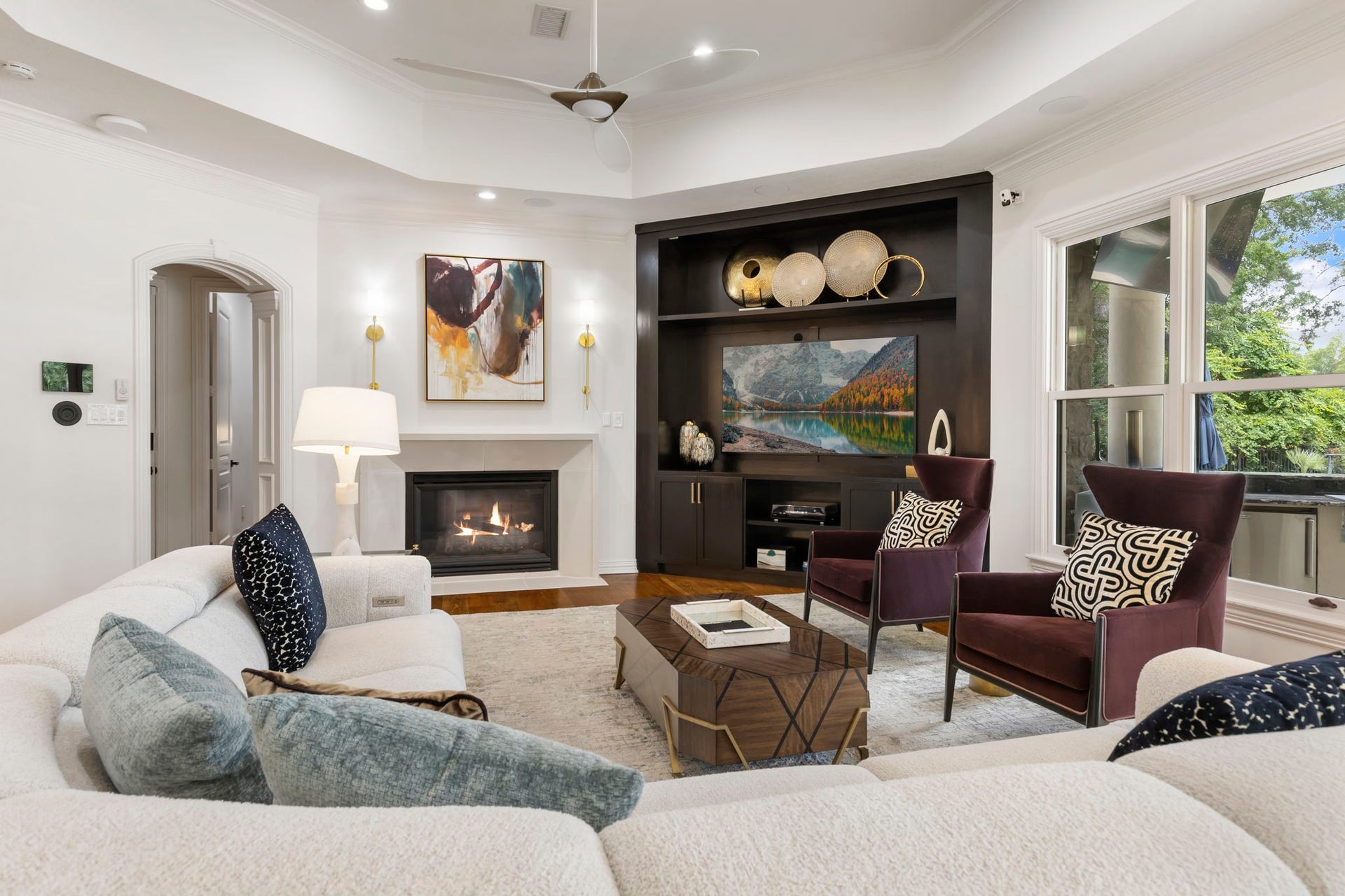 The home's second cast stone fireplace sits beside a built-in media wall.