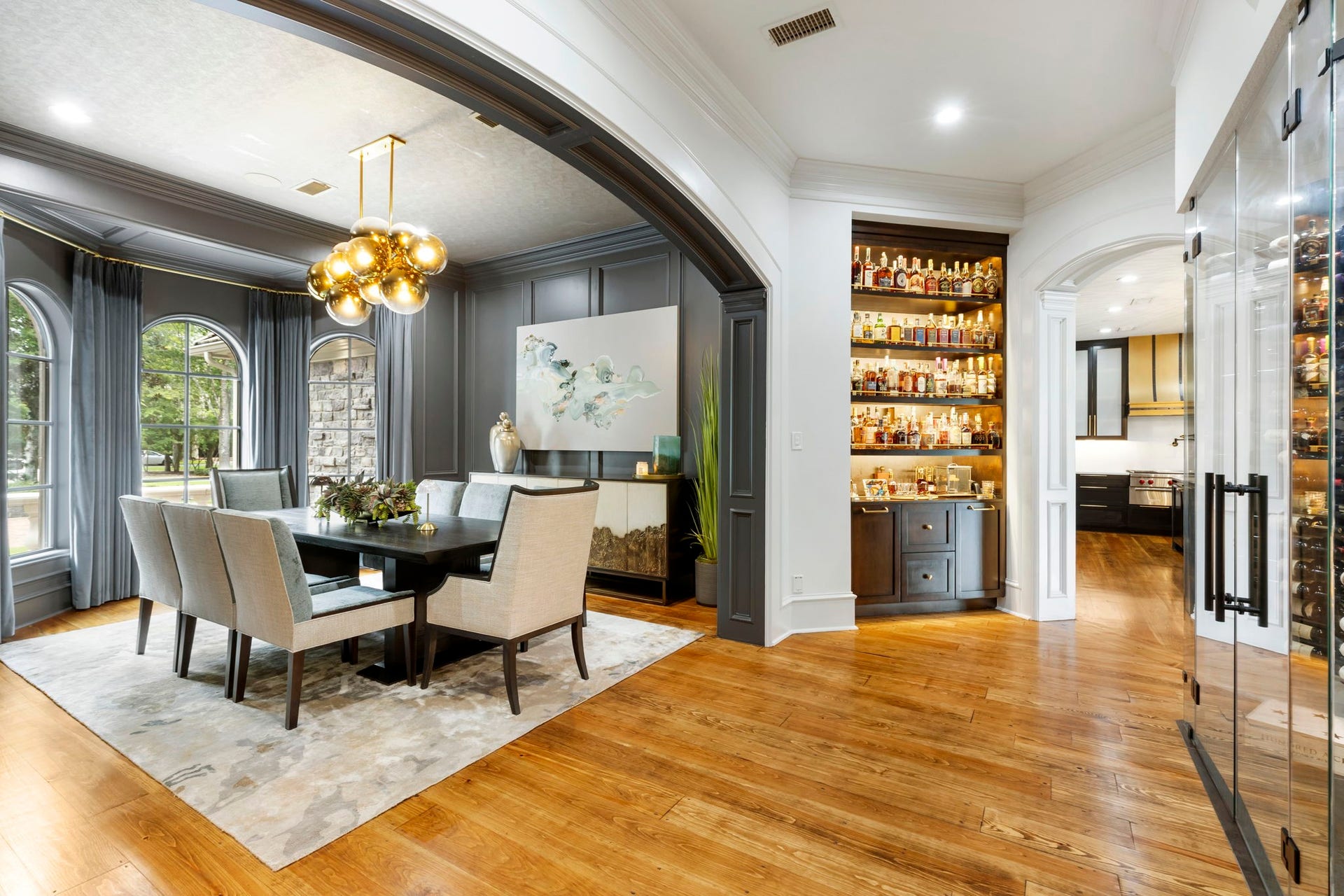 Just off the entry, deep crown molding, & an arched passage open to the dining room showcasing gorgeous painted walls and standout bubble globe chandelier.