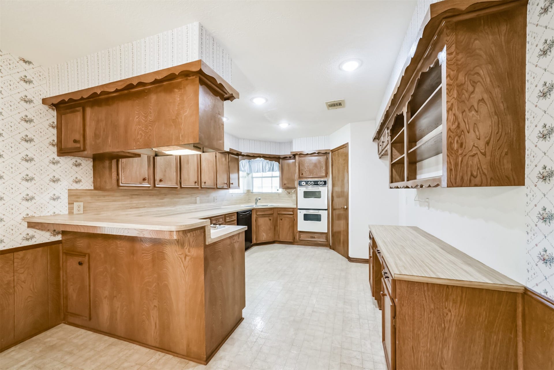601 Kimswick C Court, Deer Park, TX 77536 Heres another view of the kitchen from the dining area, highlighting the thoughtful storage and charming built-in features. A spacious pantry offers plenty of room for essentials, while the built-in buffet provides the perfect place to display cherished collectibles, family heirlooms, or decorative accents.