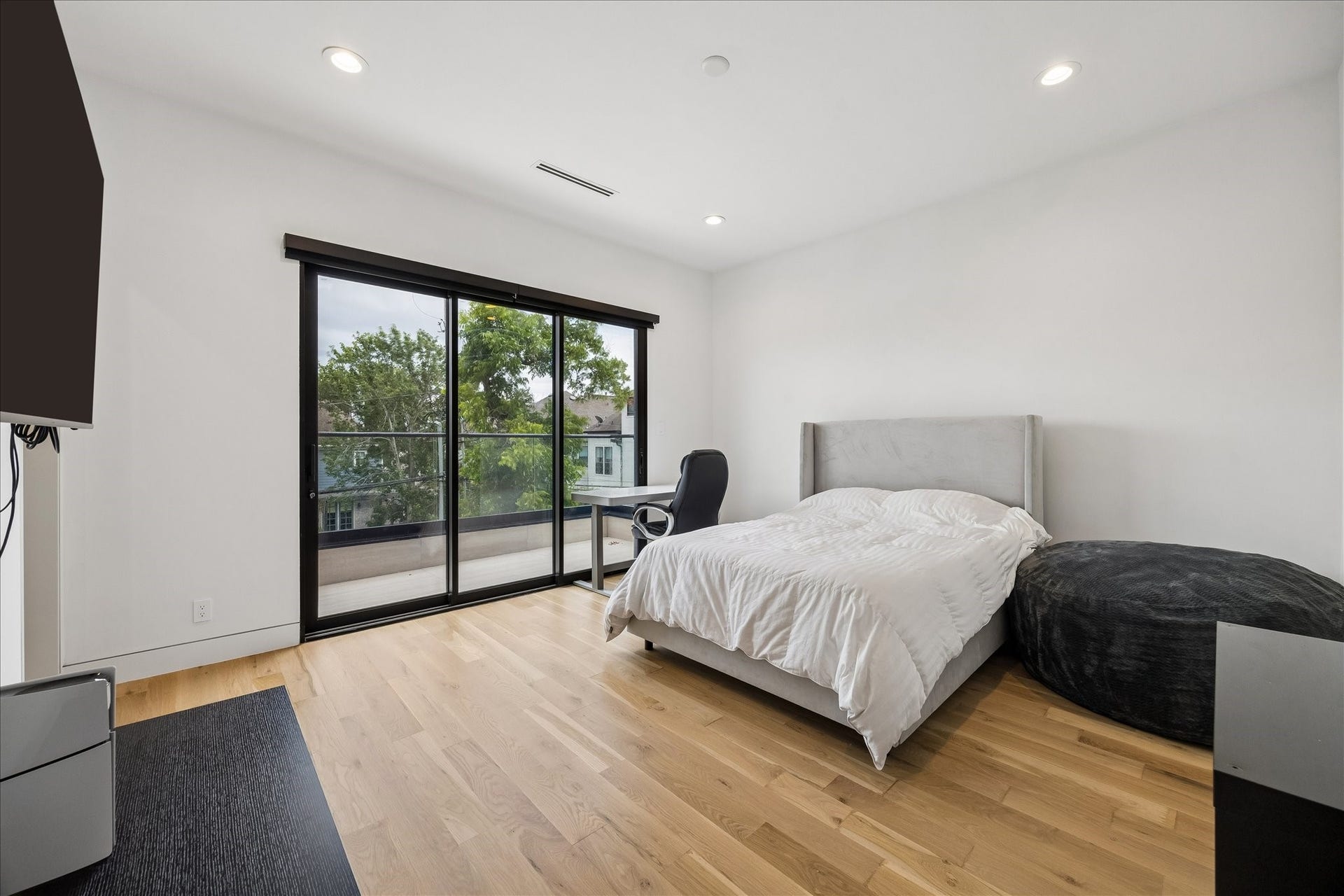 One of two secondary bedrooms features sliding glass doors leading to a balcony and an ensuite bathroom.