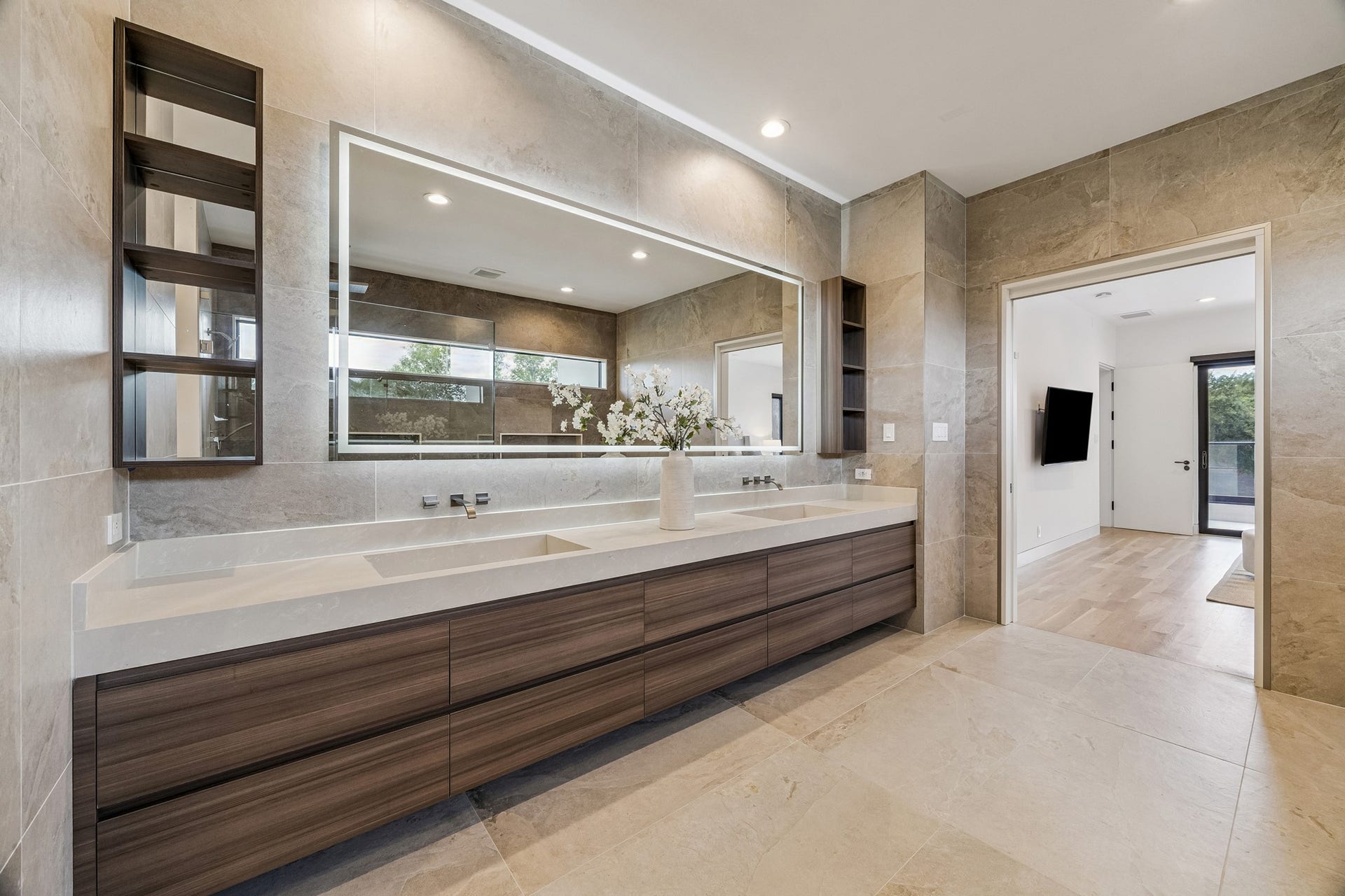 Beautiful primary bathroom with dual sinks and large LED mirror
