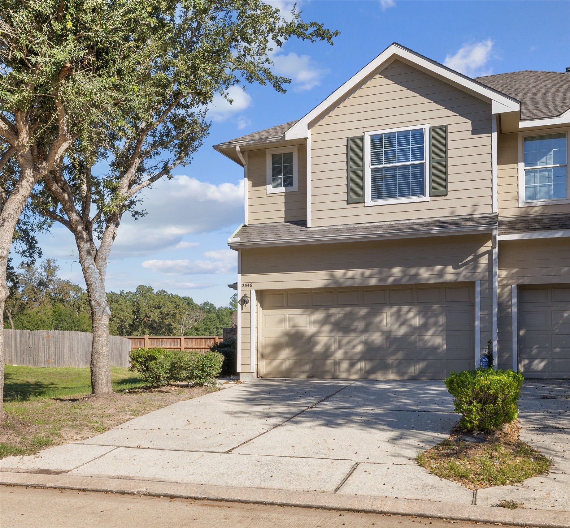 2846 Loganberry Park Lane, Houston, TX 77014 Front exterior of the two-story townhome with atwo-car attached garage and mature shade trees.