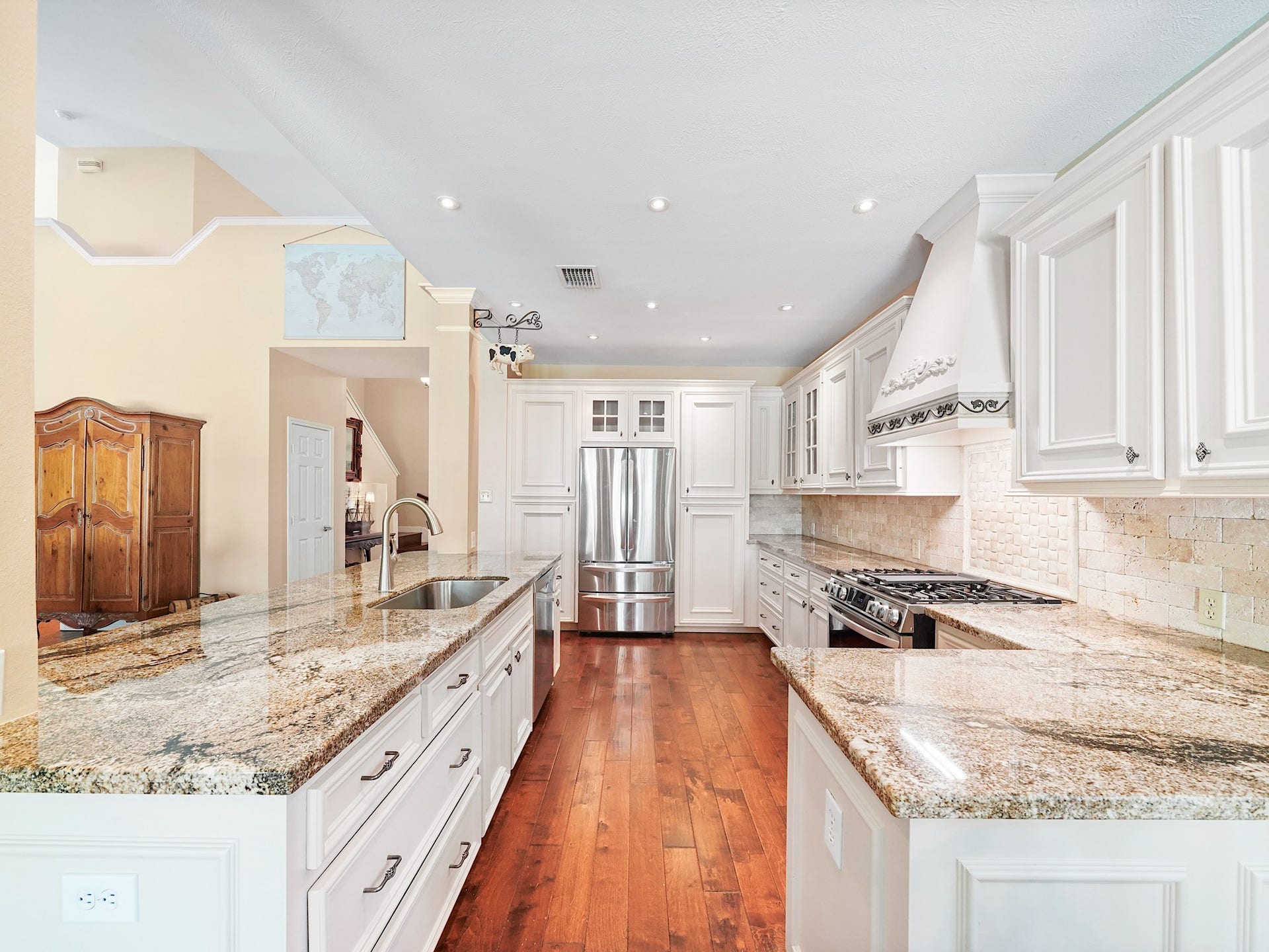 22510 Westenfield Lane, Katy, TX 77450 The kitchen pairs light cabinetry with granite countertops and warm wood flooring for a bright, welcoming feel. Generous counter space and storage make it easy to prepare everything from a quick breakfast to a holiday meal.