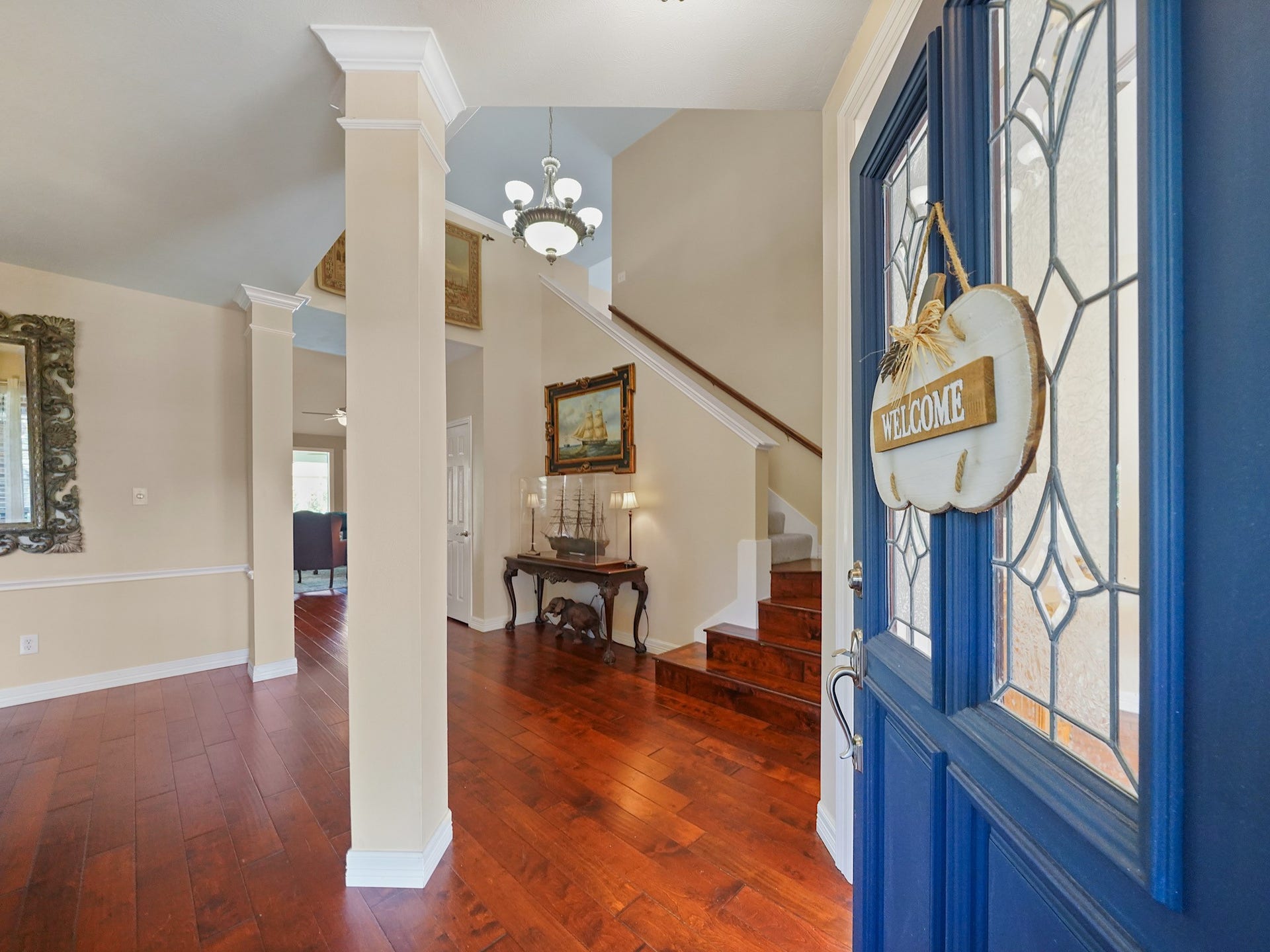 22510 Westenfield Lane, Katy, TX 77450 A blue front door with decorative glass welcomes you into the entry, where warm wood flooring leads toward the staircase and inviting spaces beyond. Its a charming first impression that sets the tone for the home.