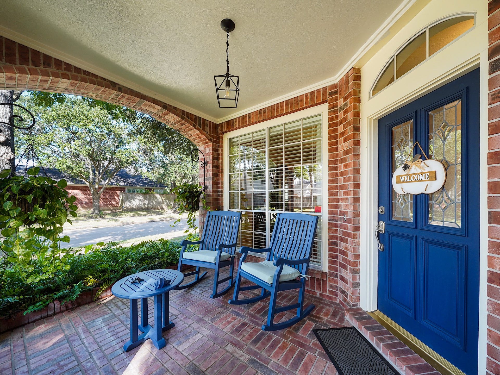 22510 Westenfield Lane, Katy, TX 77450 A welcoming front porch offers a charming place to pause and enjoy the neighborhood. The blue front door adds a cheerful touch and hints at the warmth waiting inside.