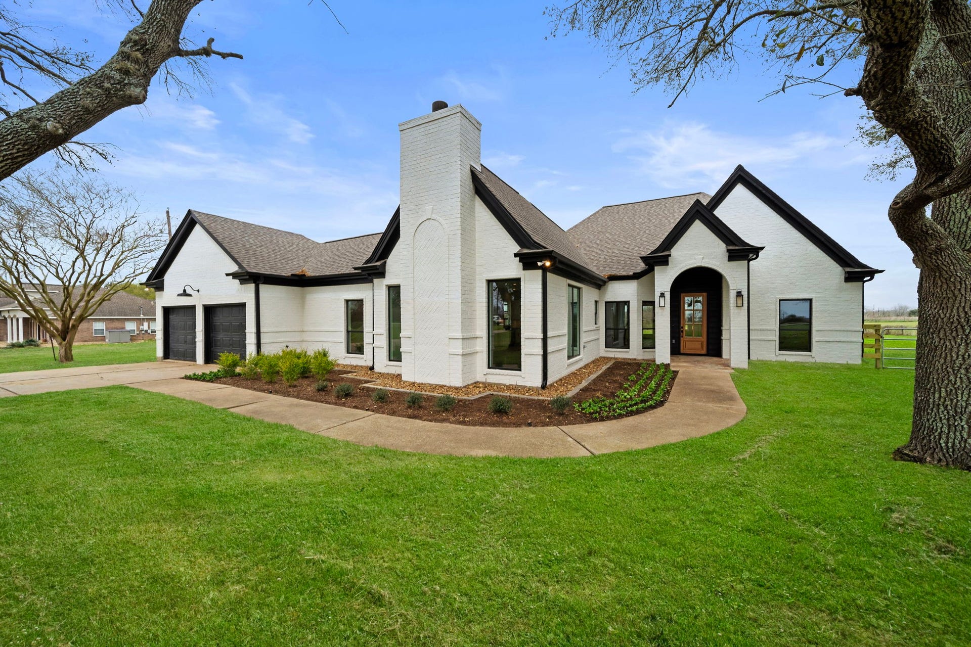 Fresh landscaping welcomes you along the wrap about walkway into the home.