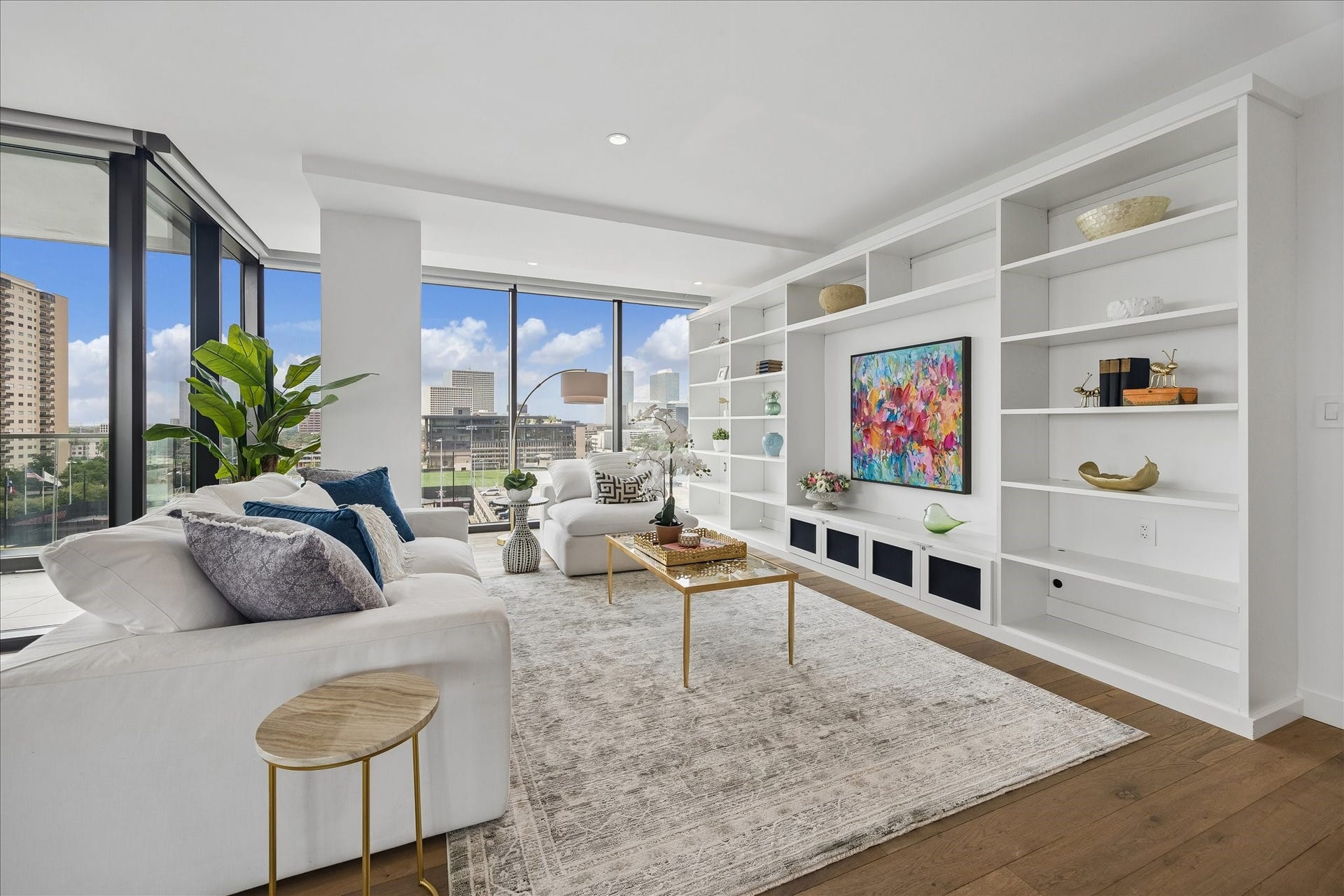 3433 Westheimer Road, #702, Houston, TX 77027 This modern living room features large floor-to-ceiling windows offering city views, sleek built-in shelving