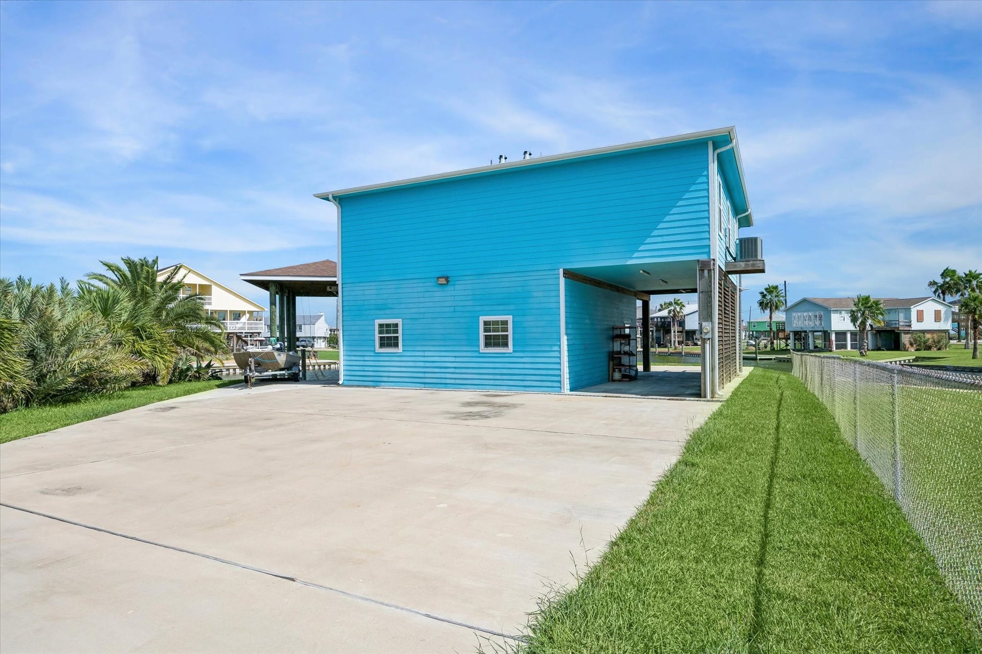 161 Four Master Road, Freeport, TX 77541 Experience coastal living in this spacious retreat, featuring vibrant blue siding, an expansive driveway, and a versatile open-air covered area perfect for soaking in the outdoors.