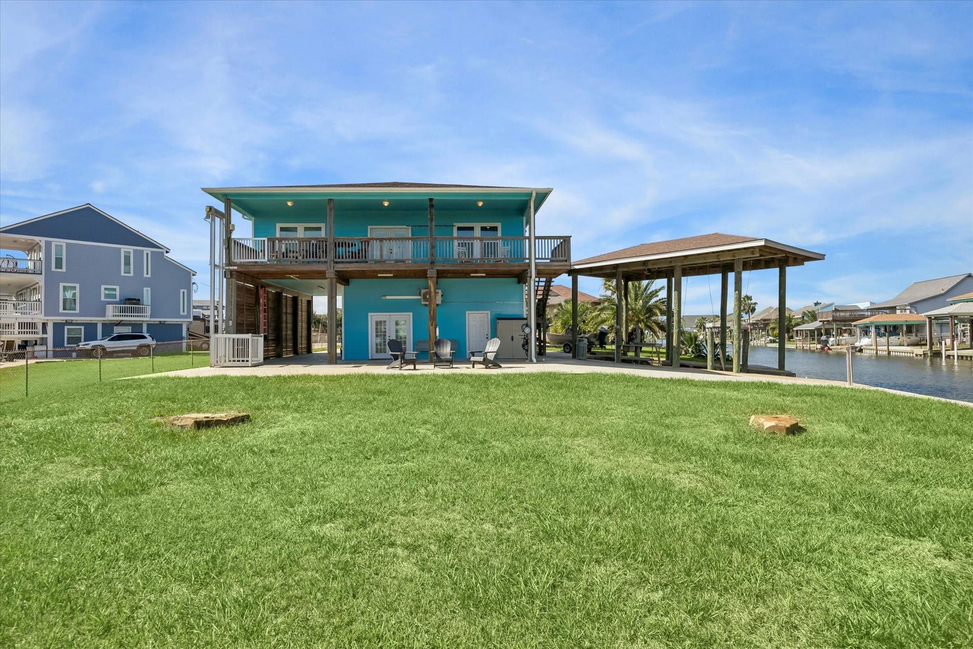 161 Four Master Road, Freeport, TX 77541 Charming waterfront home with a vibrant exterior, spacious covered porch, and direct canal access, perfect for enjoying serene water views.