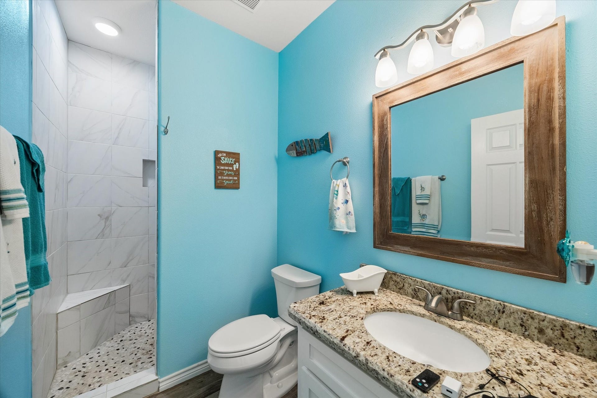 161 Four Master Road, Freeport, TX 77541 Bright and inviting bathroom with a coastal vibe, featuring a spacious walk-in shower with marble tile, granite countertop, and stylish fixtures.