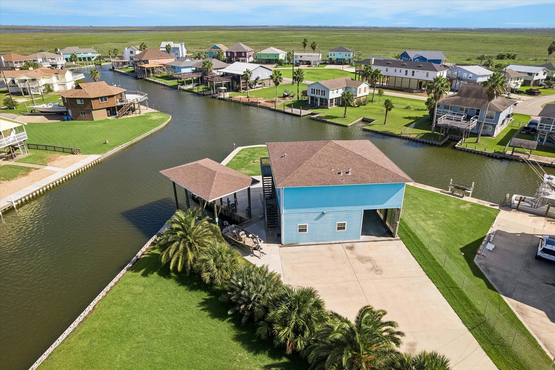 161 Four Master Road, Freeport, TX 77541 Waterfront property with a spacious boat dock, surrounded by lush greenery and offering direct canal access. Ideal for boating enthusiasts.