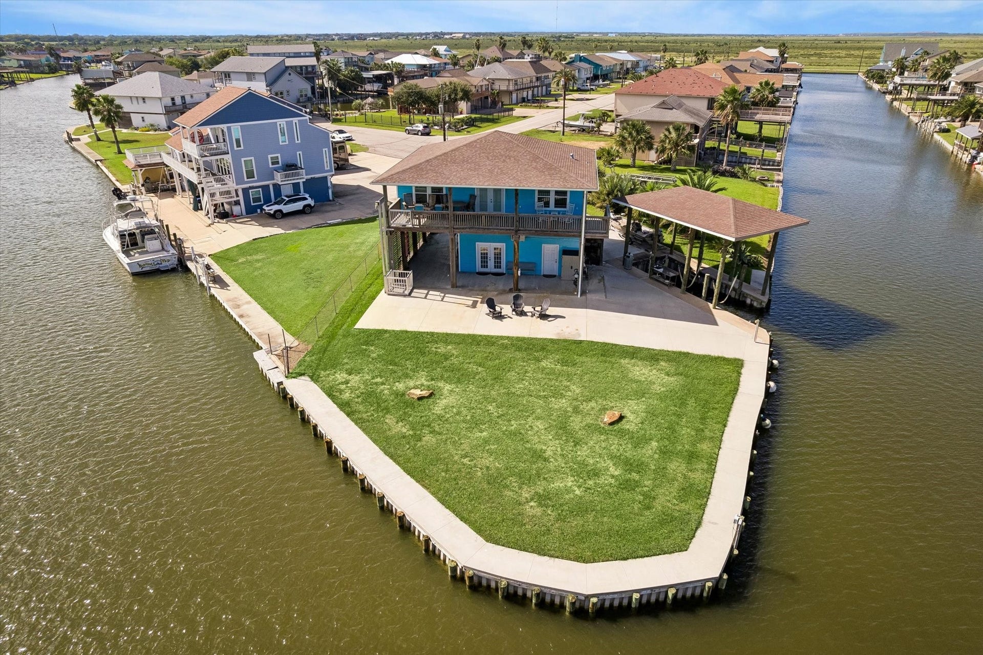 161 Four Master Road, Freeport, TX 77541 Charming waterfront home on a spacious canal-front lot, featuring a large deck, boat dock, and lush green lawn perfect for outdoor enjoyment.Located on a corner lot with 180 degree view.