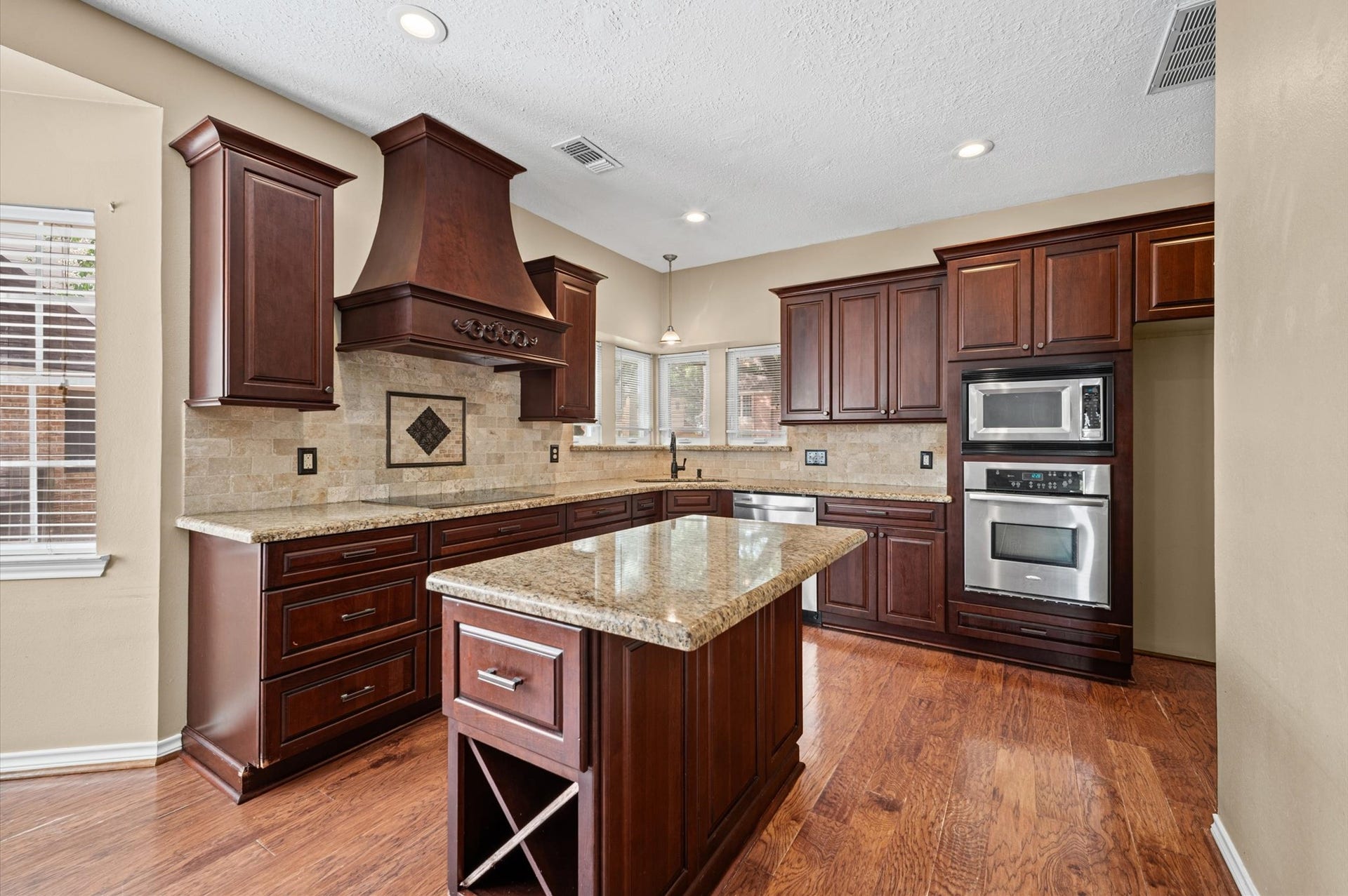 13126 Lemur Lane, Cypress, TX 77429 This gorgeous kitchen is open to living room and features beautiful soft close cabinetry with granite countertops, functional island, wood floors, large breakfast area and a chef's planning station.