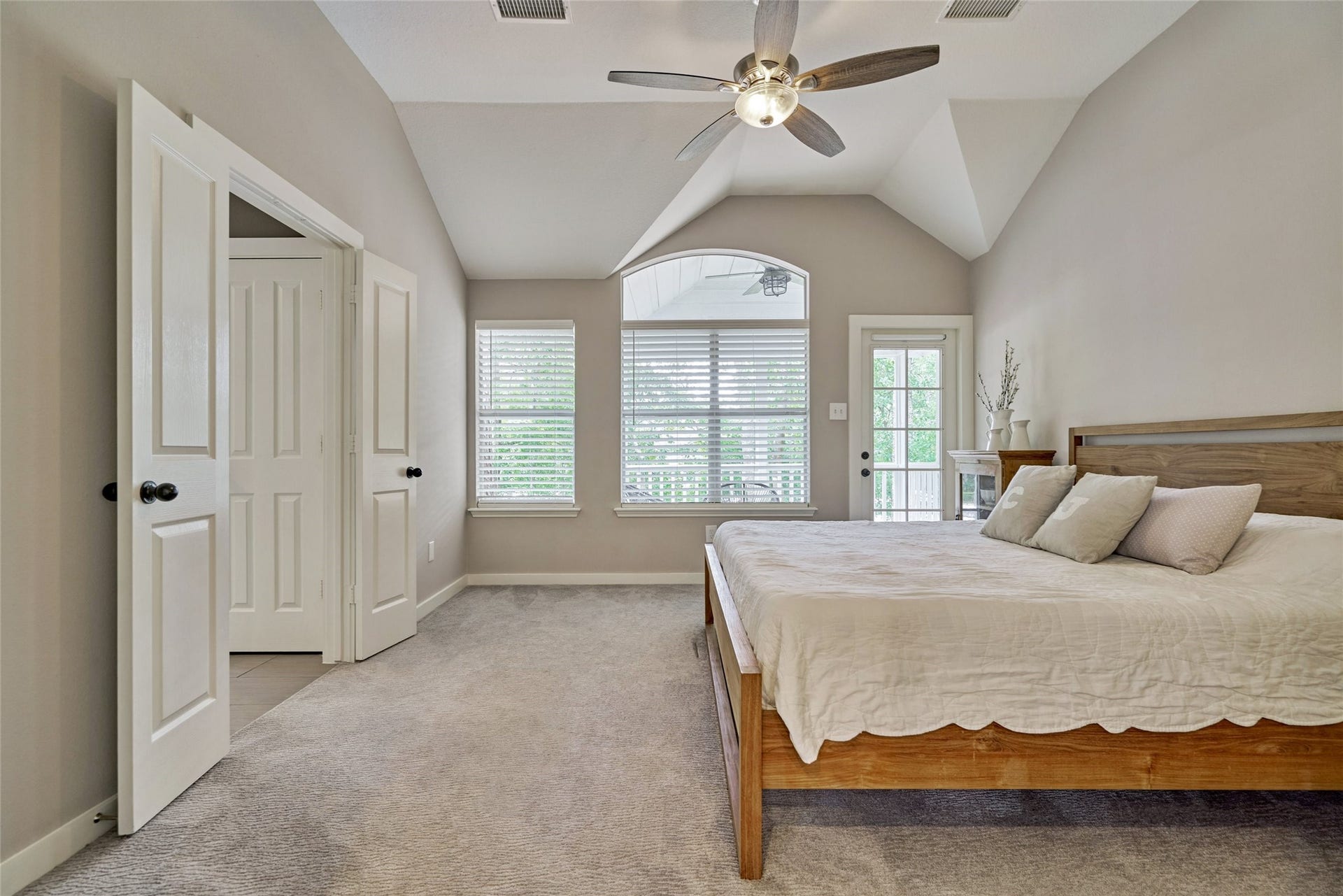 38 E Gaslight Place, The Woodlands, TX 77382 The primary bedroom is located upstairs and features vaulted ceilings, neutral decor, updated hardware, LED lighting and and fan.