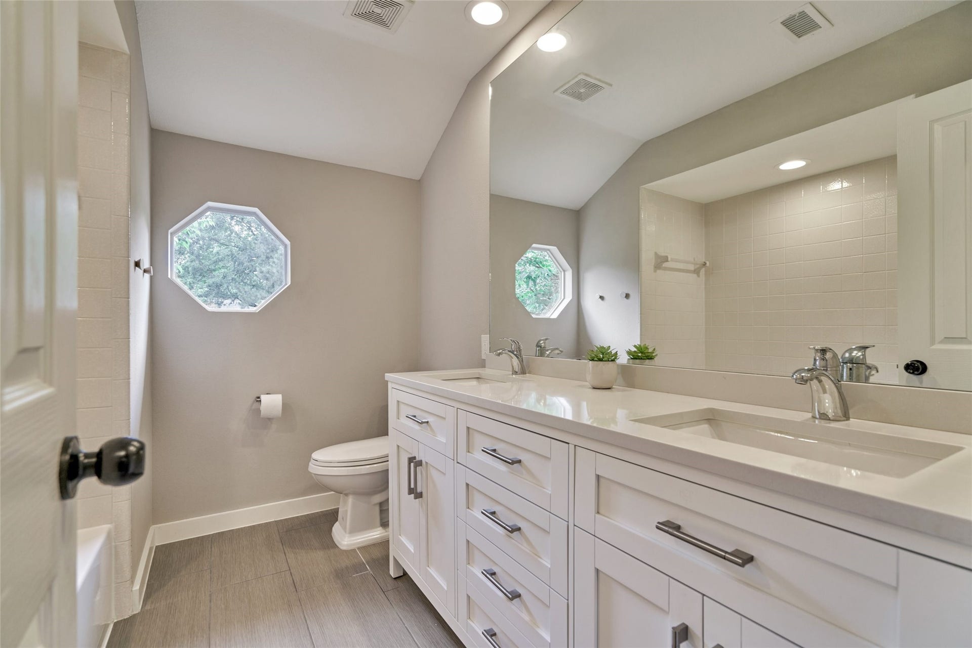 38 E Gaslight Place, The Woodlands, TX 77382 The secondary full bathroom upstairs features a sleek vanity with lots of storage, upgraded tile floors, LED lighting. I just LOVE the octagonal window!