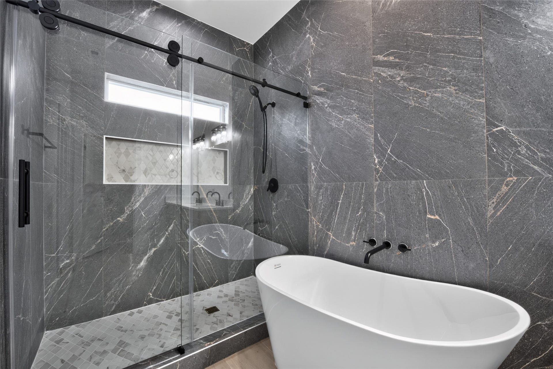 Oversized and beautifully finished, the shower features sliding glass doors and floor-to-ceiling tile for a sleek, sophisticated look.