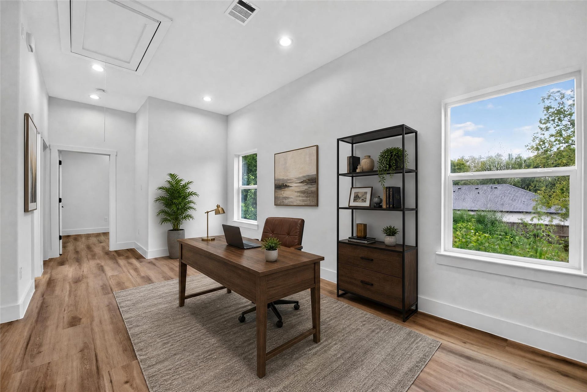 A spacious, light-filled flex space showcased as a stylish home office, perfectly positioned between the private primary suite on one side and two secondary bedrooms with a full bath on the other. Flexible by design and ready to make your own.