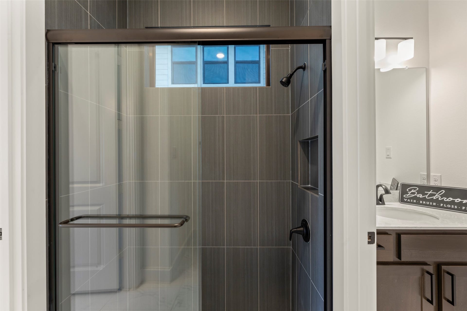2015 Jade Manor Drive, Rosenberg, TX 77469 Glass-enclosed shower with sleek dark tiles and a convenient built-in niche.