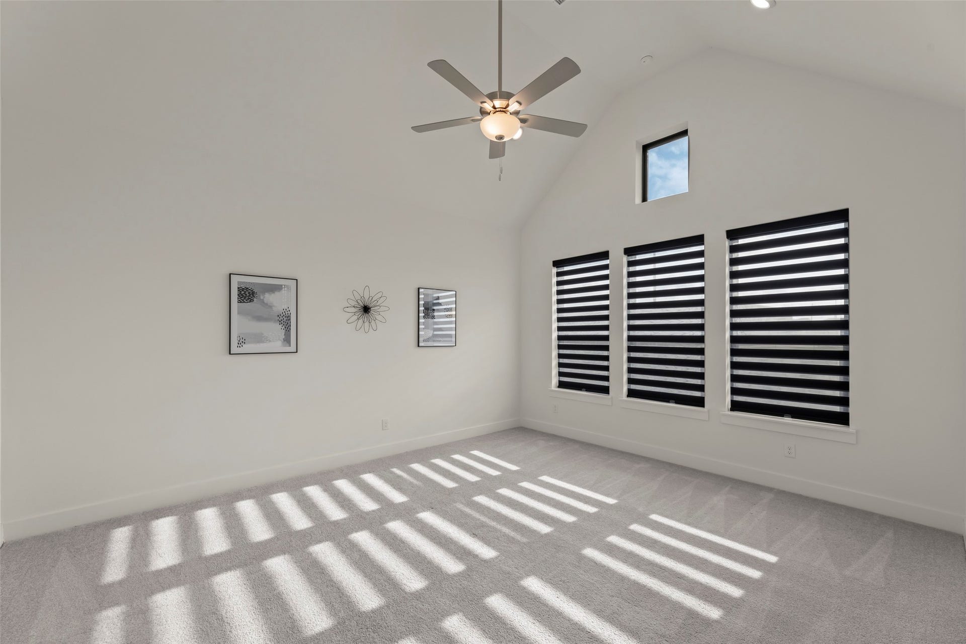 2015 Jade Manor Drive, Rosenberg, TX 77469 Beautiful room with vaulted ceilings, modern ceiling fan, and stylish striped window blinds, perfect for a cozy retreat.