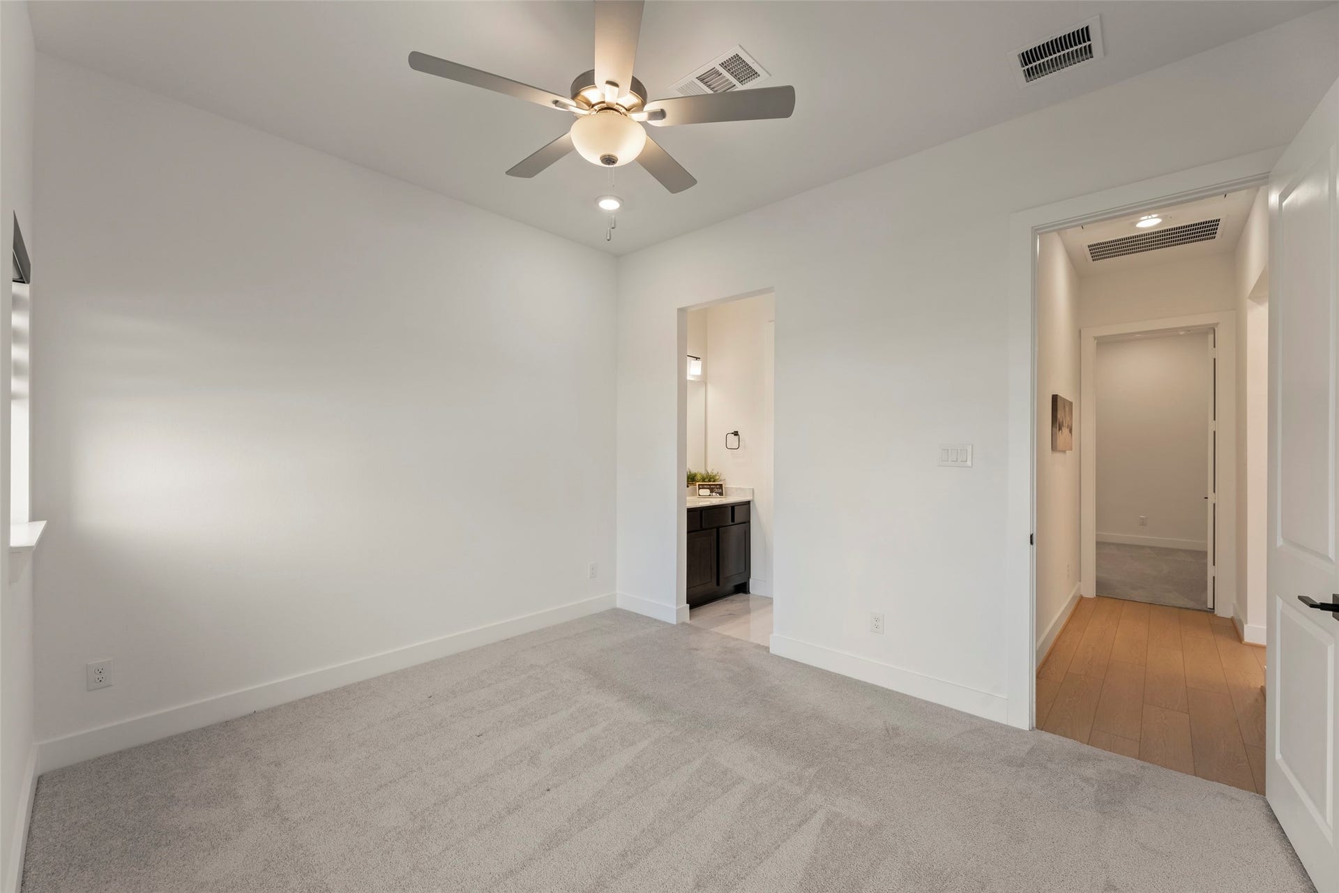 2015 Jade Manor Drive, Rosenberg, TX 77469 Ensuite bathroom and access to a hallway with elegant wood flooring.