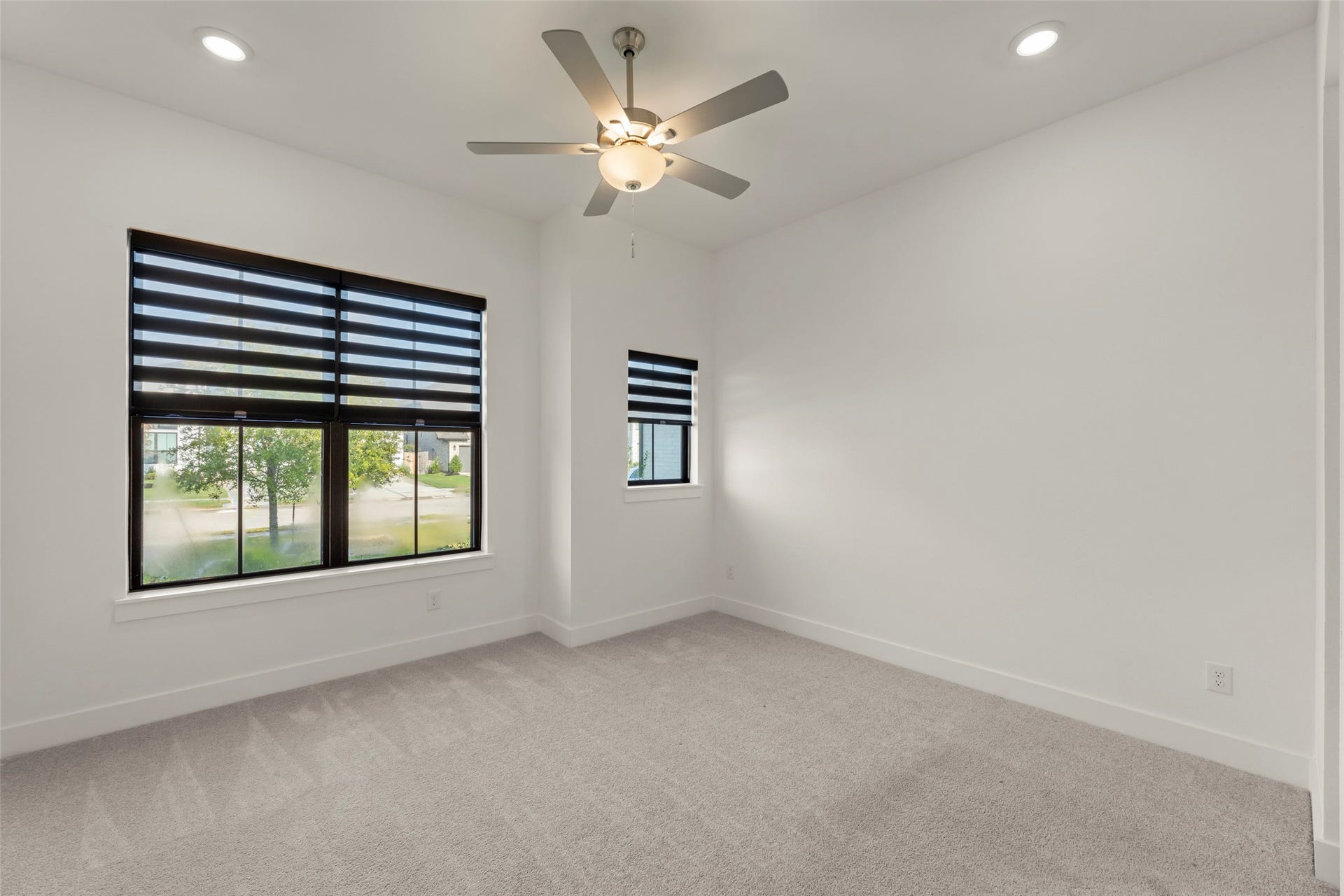 2015 Jade Manor Drive, Rosenberg, TX 77469 Vibrant room with large windows, modern blinds, plush carpeting, and a ceiling fan for comfort.