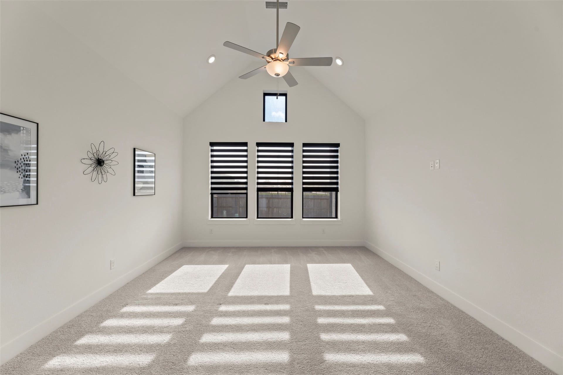 2015 Jade Manor Drive, Rosenberg, TX 77469 Primary bedroom with high ceilings, abundant natural light, and modern fan, perfect for relaxation or entertainment.