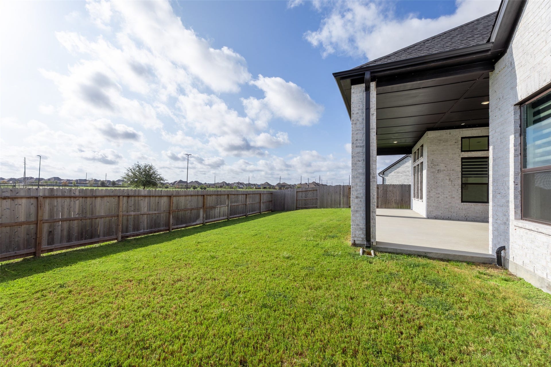 2015 Jade Manor Drive, Rosenberg, TX 77469 Lush green lawn and a spacious covered patio, perfect for outdoor relaxation and entertaining.
