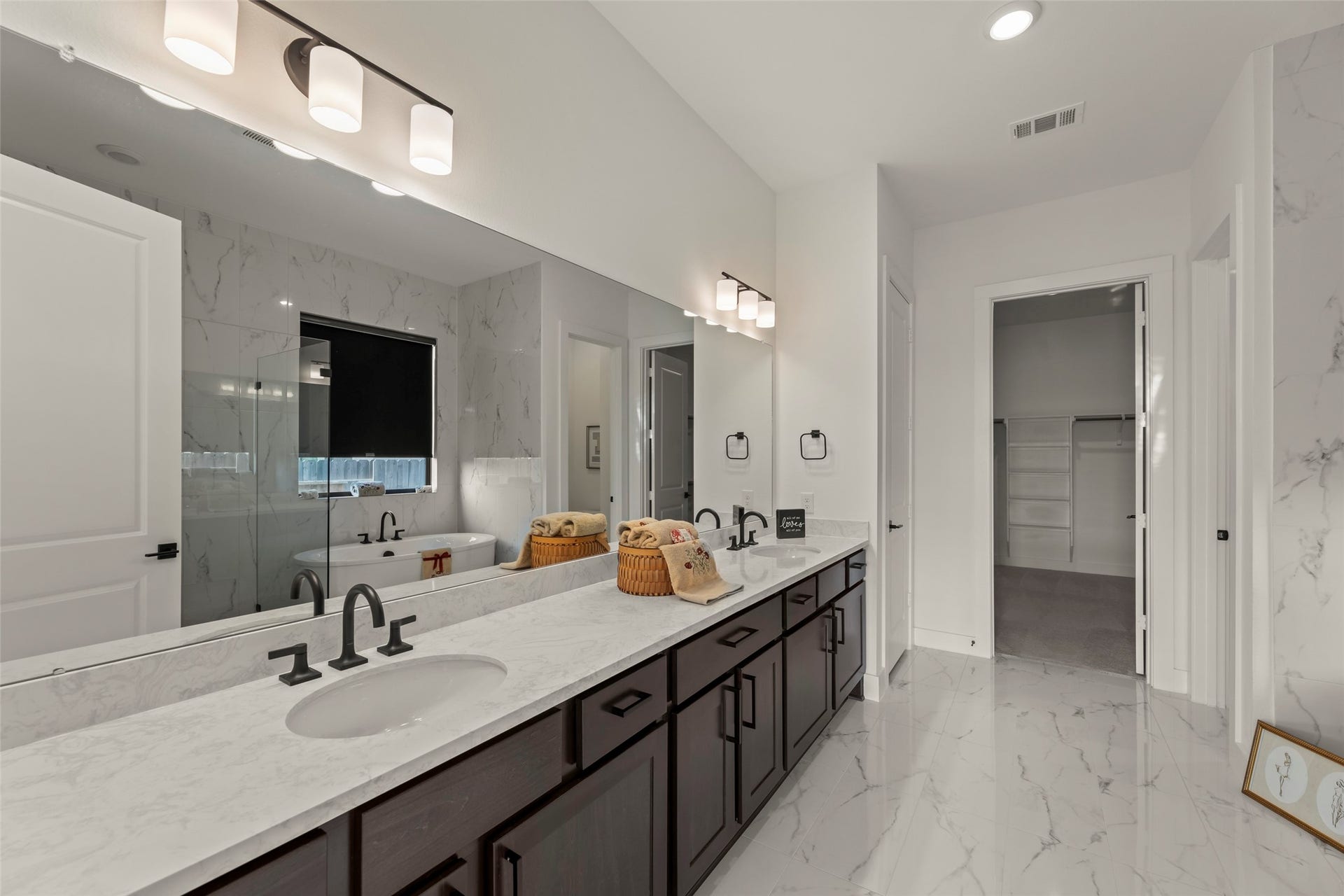 2015 Jade Manor Drive, Rosenberg, TX 77469 Luxurious bathroom featuring a dual-sink vanity with elegant marble countertops, modern fixtures, and a spacious walk-in closet.