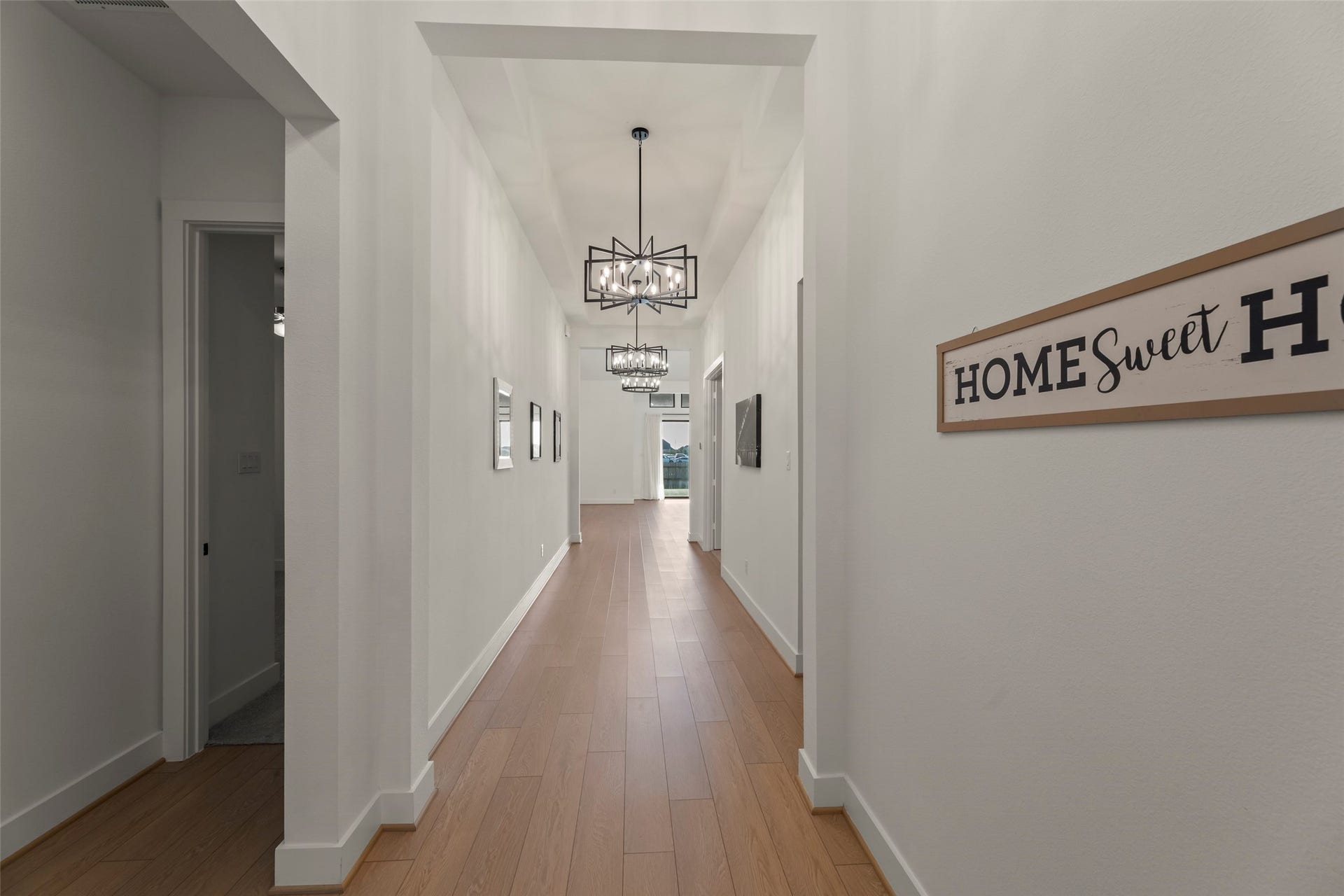 2015 Jade Manor Drive, Rosenberg, TX 77469 Lit entryway with modern light fixtures and warm wood flooring leads to the heart of the home.