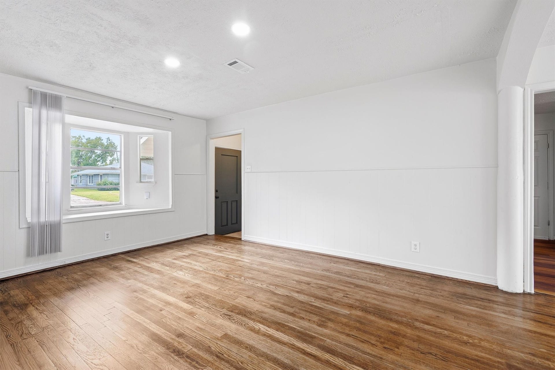 6630 Maybank Drive, Houston, TX 77055 Bright and inviting living space featuring hardwood floors, fresh white walls, and a charming bay window that offers plenty of natural light.