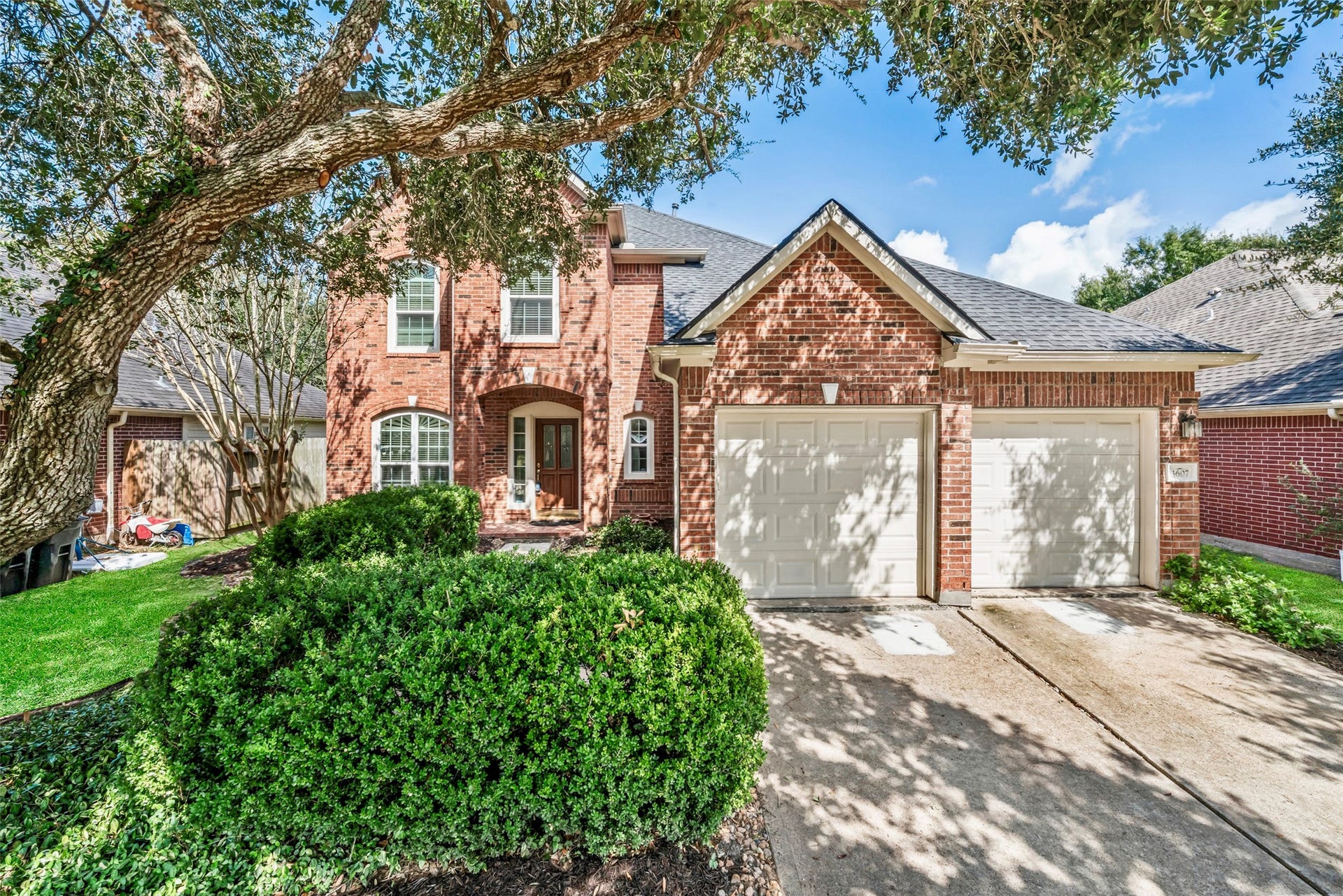 3607 Parkshire Drive, Pearland, TX 77584 Charming brick home with a two-car garage, double-wide driveway and beautifully landscaped front yard, shaded by a canopy of mature trees for added curb appeal.