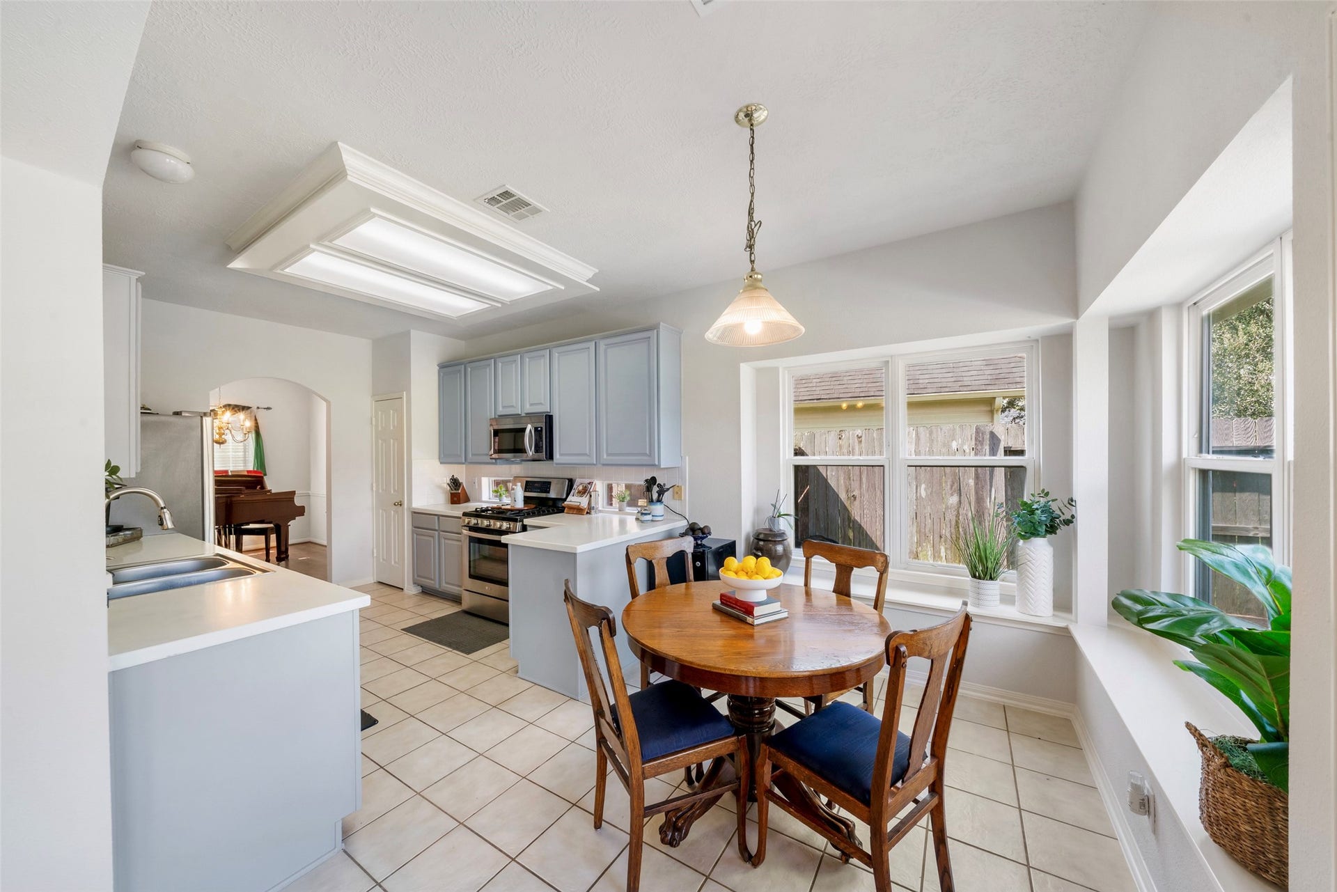3607 Parkshire Drive, Pearland, TX 77584 Bright kitchen with modern appliances, spacious countertops, and a cozy dining nook surrounded by large windows.