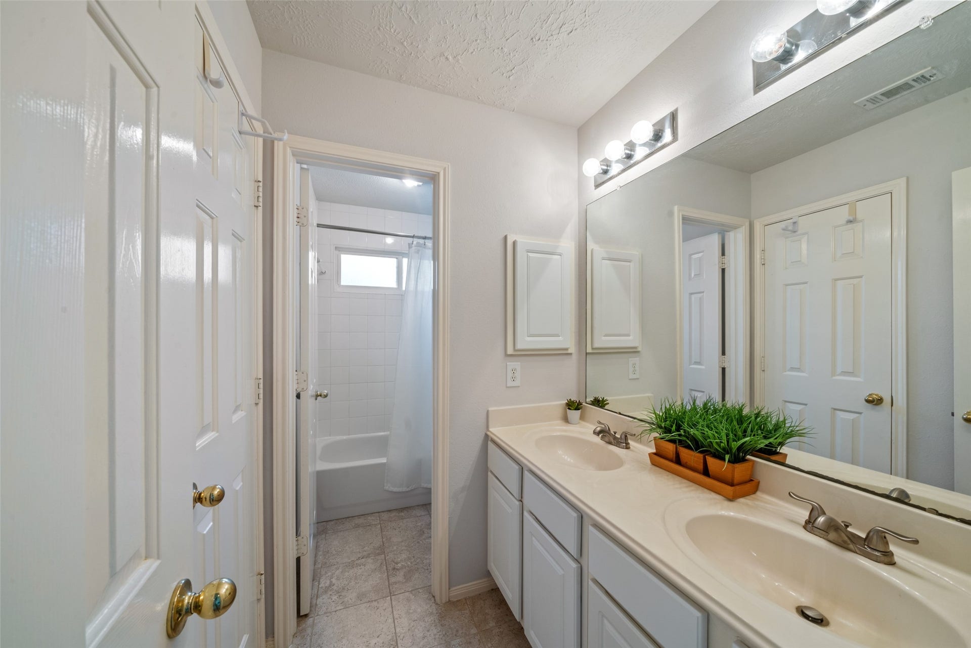 3607 Parkshire Drive, Pearland, TX 77584 Bright bathroom featuring a double vanity with ample counter space, elegant lighting, and a shower-tub combination for convenience.
