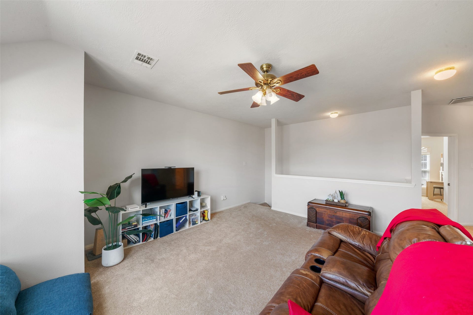 3607 Parkshire Drive, Pearland, TX 77584 Cozy game room featuring plush carpeting, a ceiling fan, and ample natural light, perfect for relaxation and entertainment.