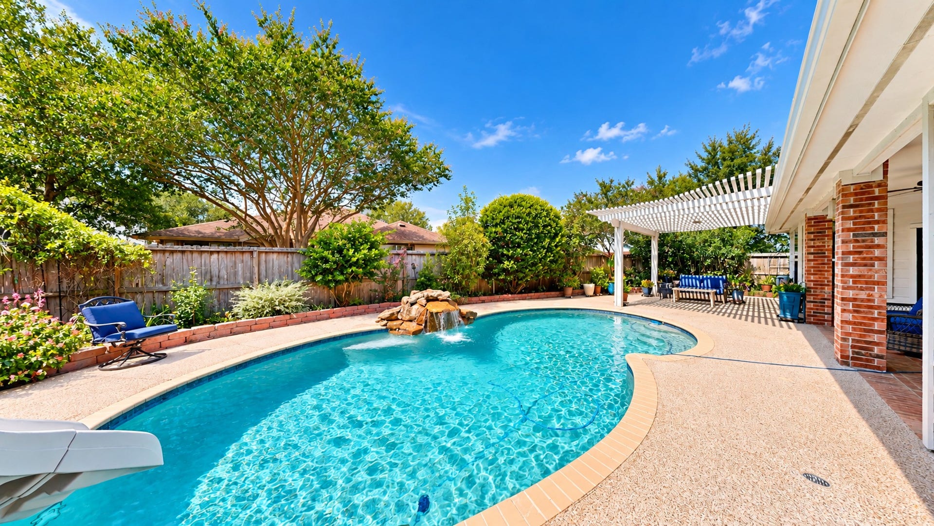 3511 Harbor Pass Lane, Friendswood, TX 77546 Experience outdoor luxury with a sparkling pool, waterfall feature, and a shaded pergola perfect for relaxing and entertaining.