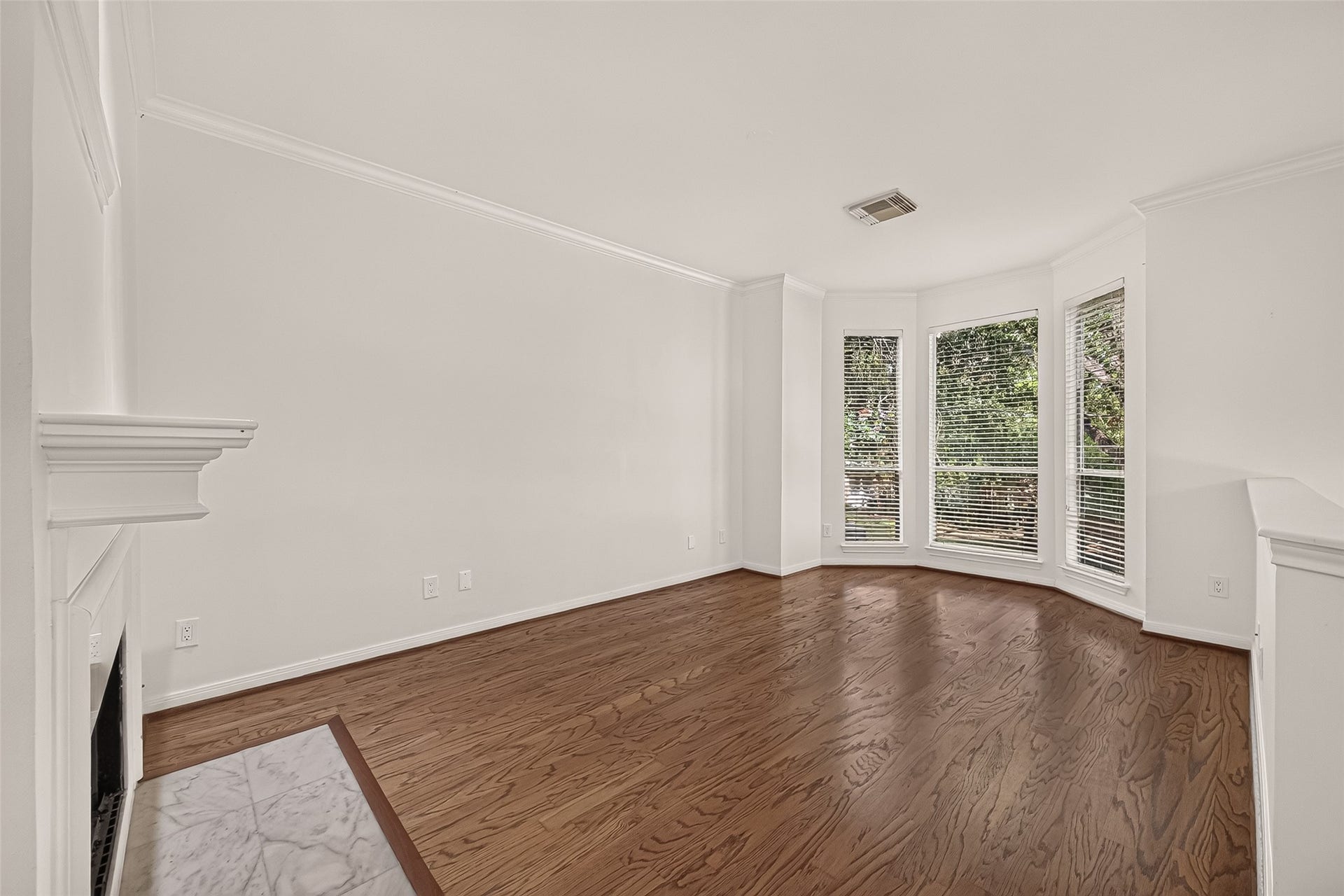 2903 Austin Street, Houston, TX 77004 The second-floor living room offers a welcoming place to relax, featuring bay windows, warm wood flooring, and a beautifully updated fireplace with a new marble surround.