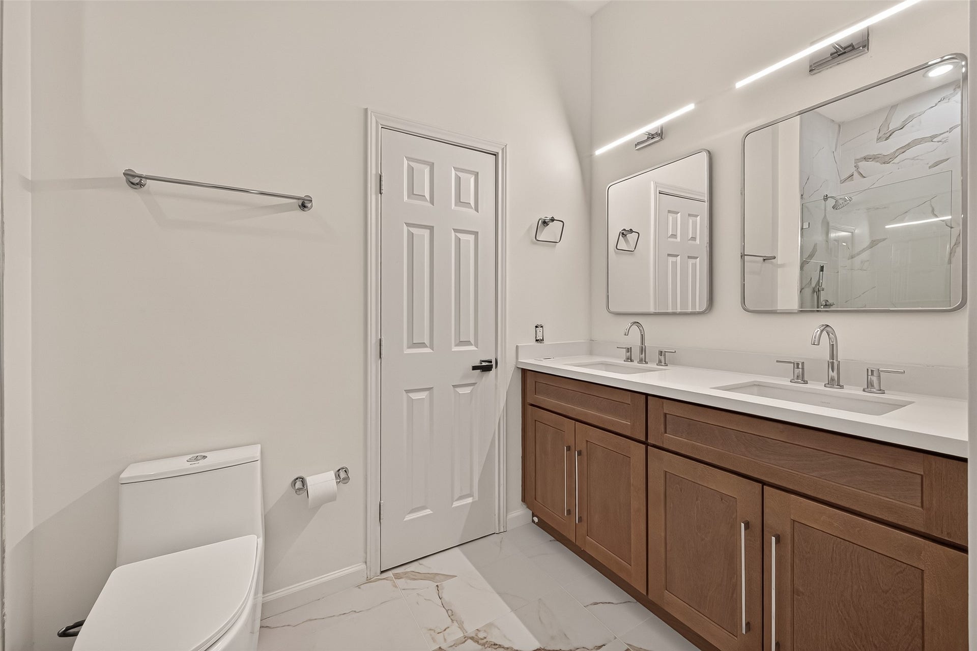 2903 Austin Street, Houston, TX 77004 Updated primary bathroom featuring a double-sink vanity, lighted mirrors, and modern light fixtures for a clean, contemporary look.