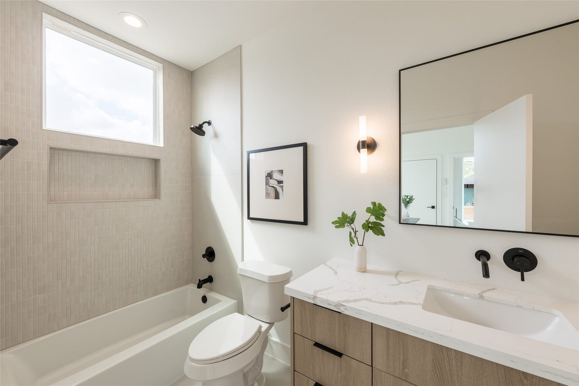 2009 Gregg Street, Houston, TX 77026 Bright and modern bathroom featuring a sleek vanity with a marble countertop, contemporary fixtures, and a spacious bathtub with a large window for natural light.